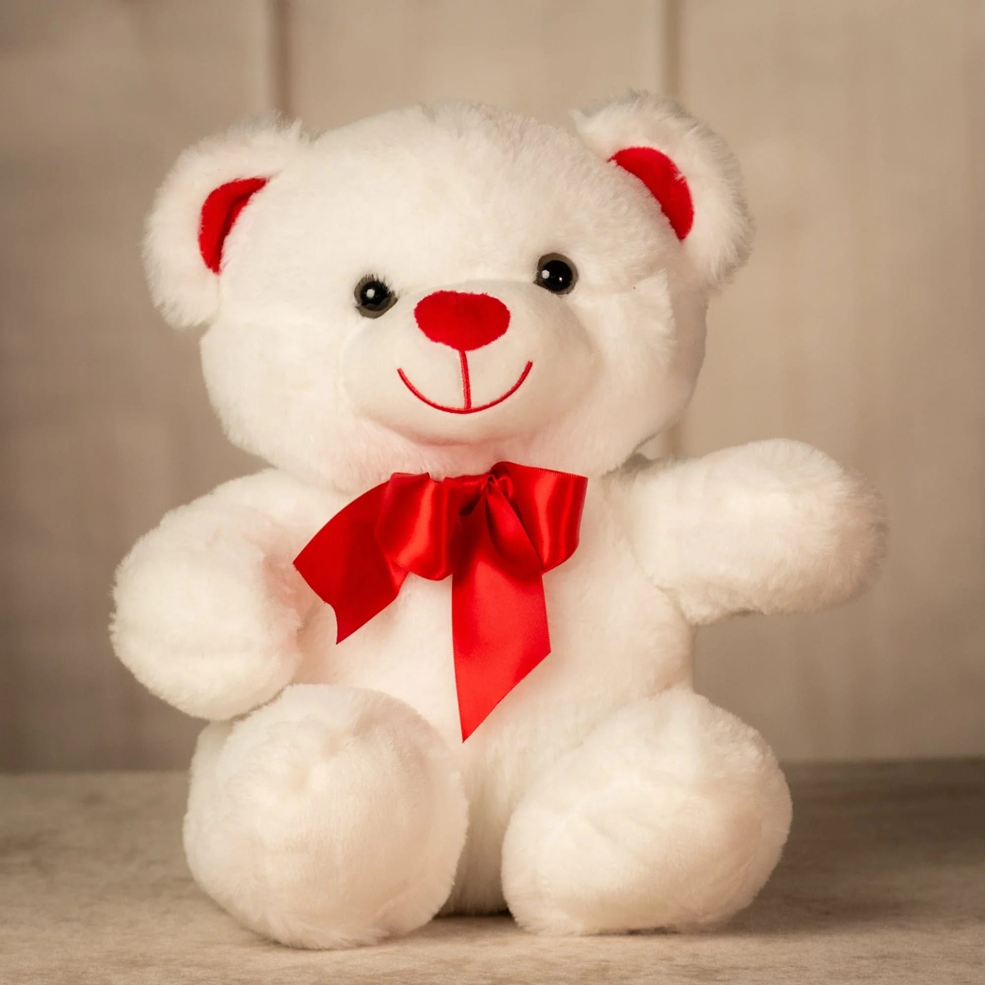 White teddy bear with a red bow and red nose