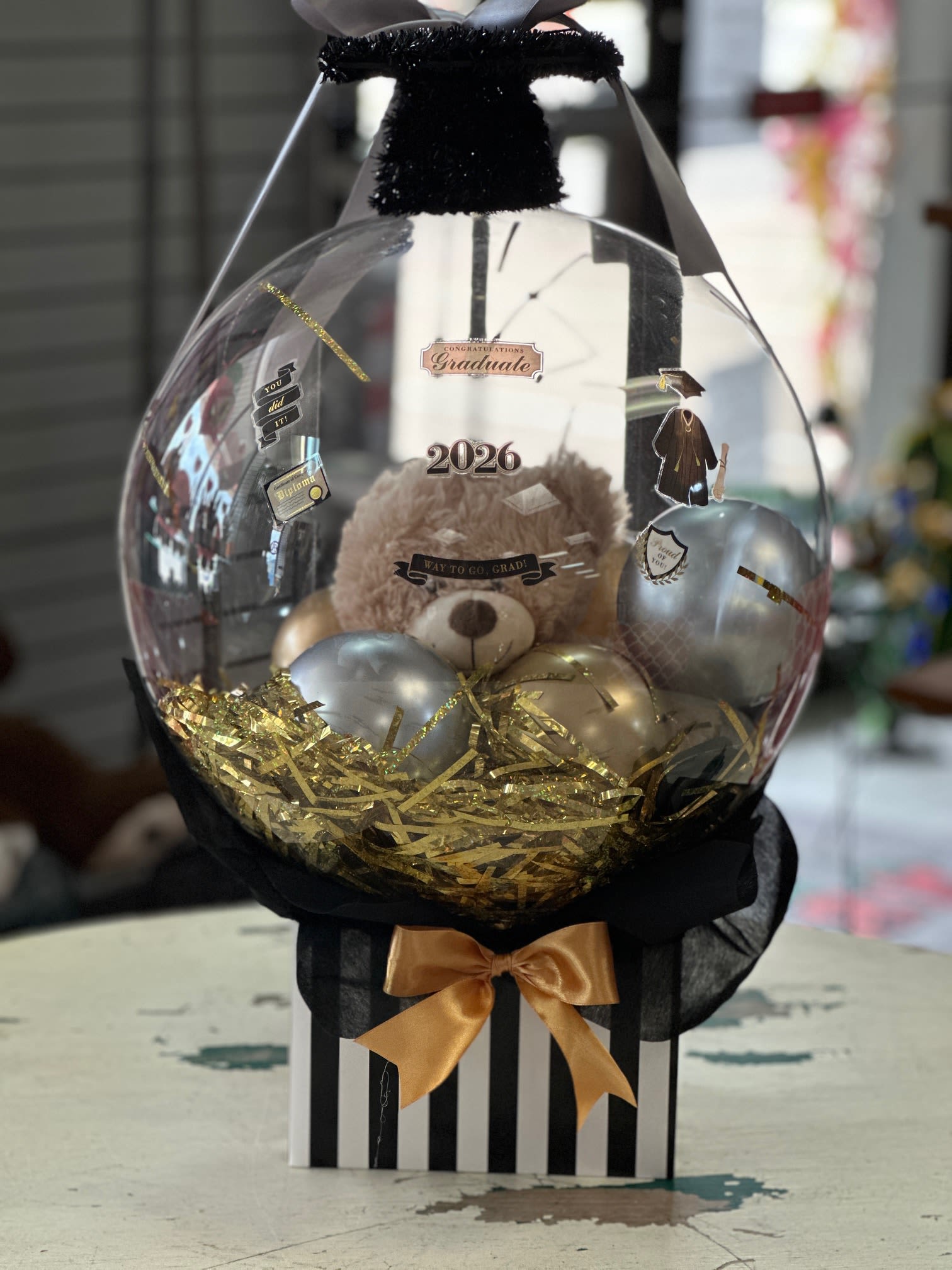 Graduation Bobo Balloon Gift Set - Make their graduation extra special with this adorable and unique balloon gift. This design features a handful of small balloons along with a 10" teddy bear nestled inside a box with tissue paper. 