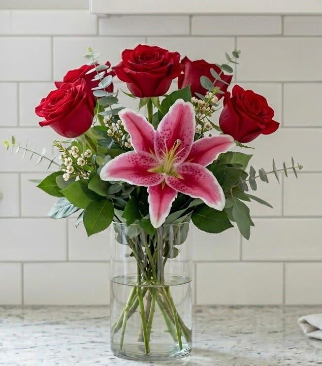 Half Dozen Red Rose with Lily - A simply elegant arrangement with 6 red roses and a pink or white lily. A special arrangement for someone special in your life. 