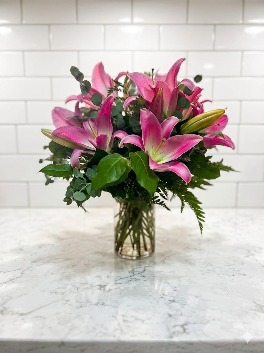 Simply Lily-Pink - The color pink takes a well deserved bow on center stage in this splendid and lovely lily arrangement complemented by a clear cylinder vase and curly willow accents. Measures 18"H by 14"L.