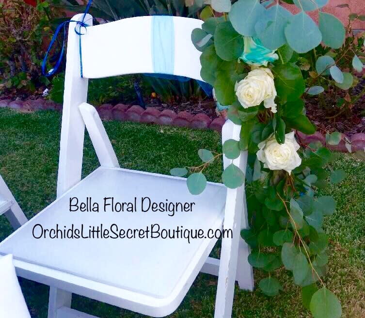 White chair decorated with eucalyptus and white roses