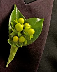 Green boutonniere with yellow berries on a dark jacket