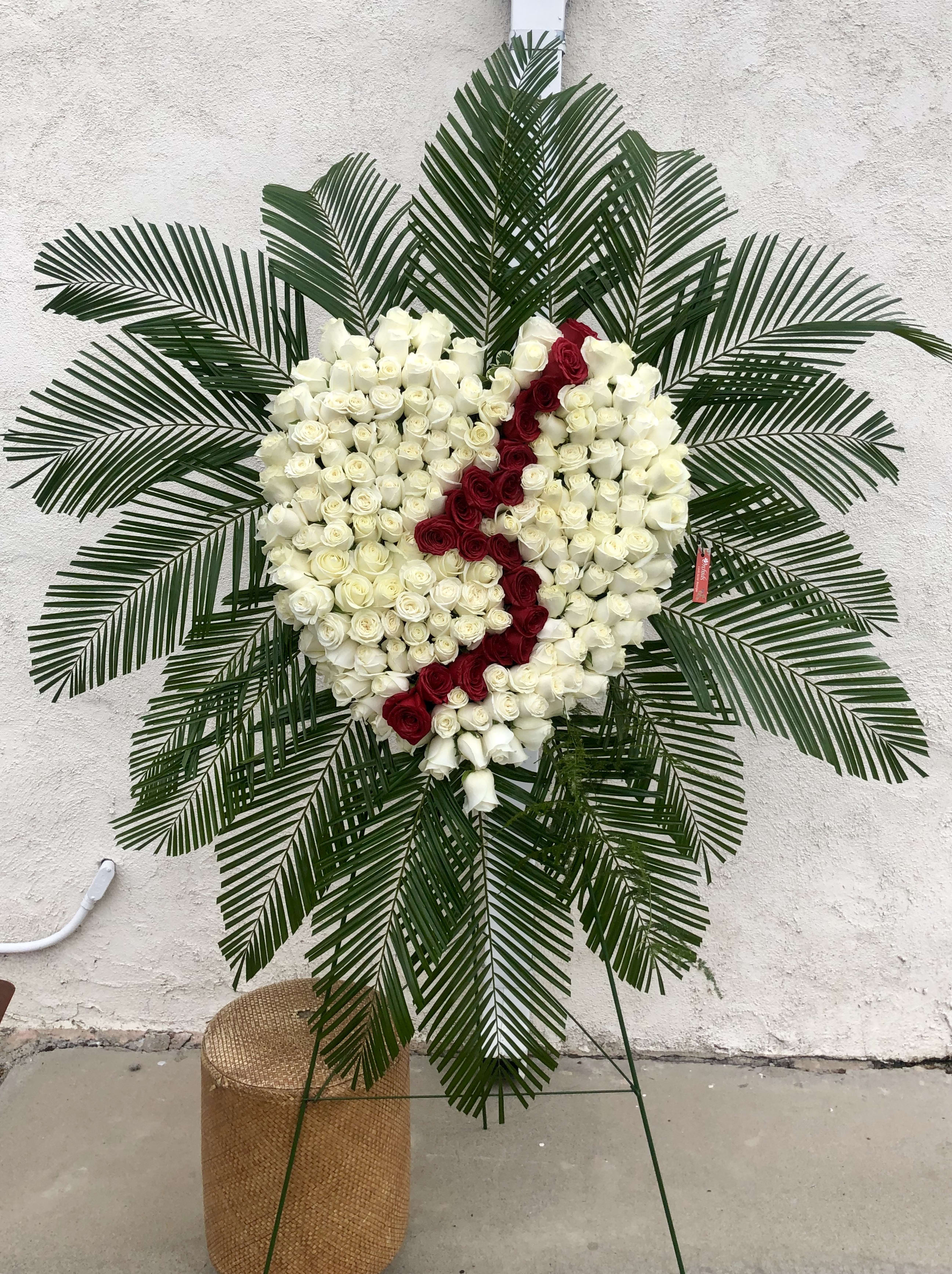 Heart-shaped rose wreath with white and red roses on a stand
