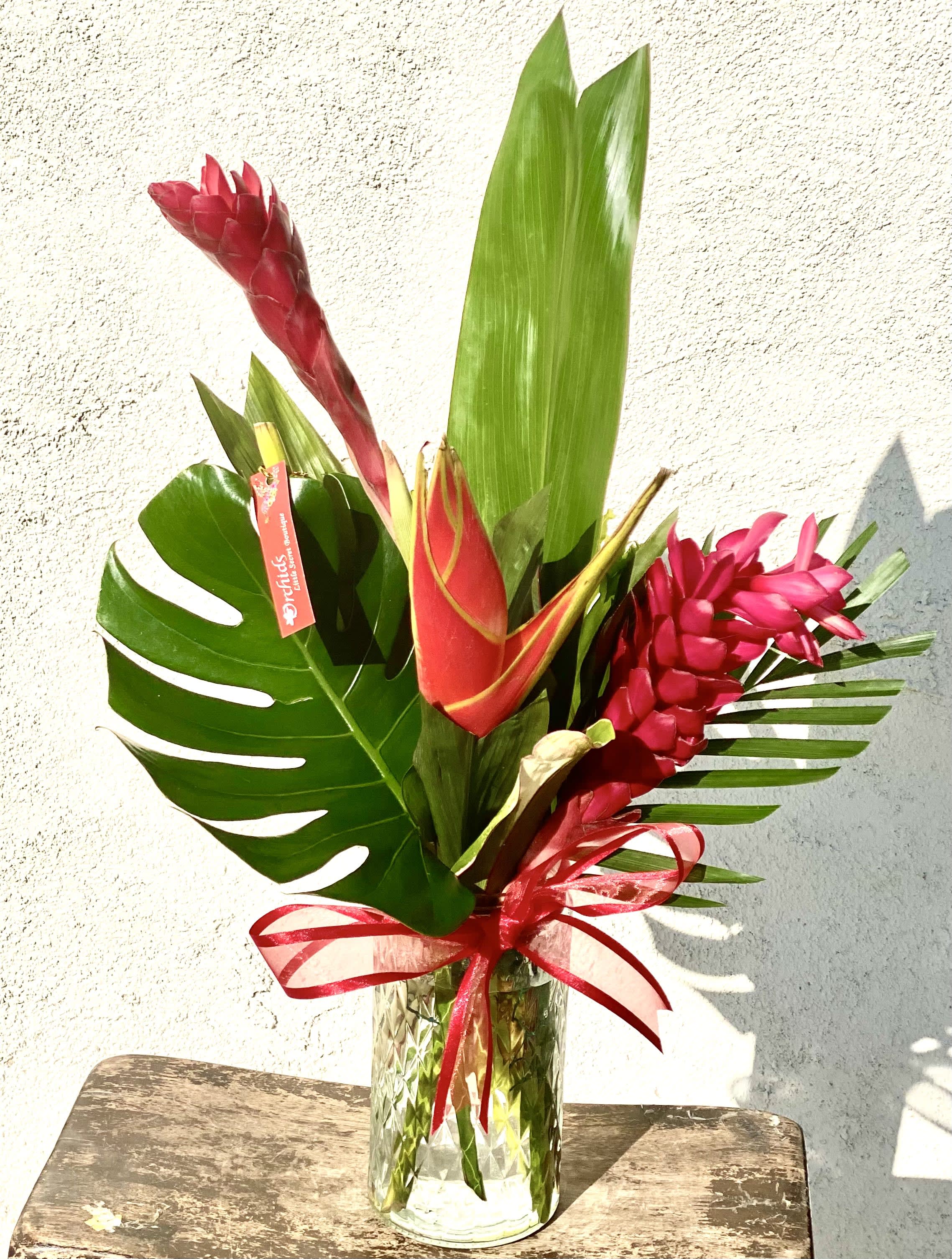 Tropical bouquet with red ginger flowers in a glass vase