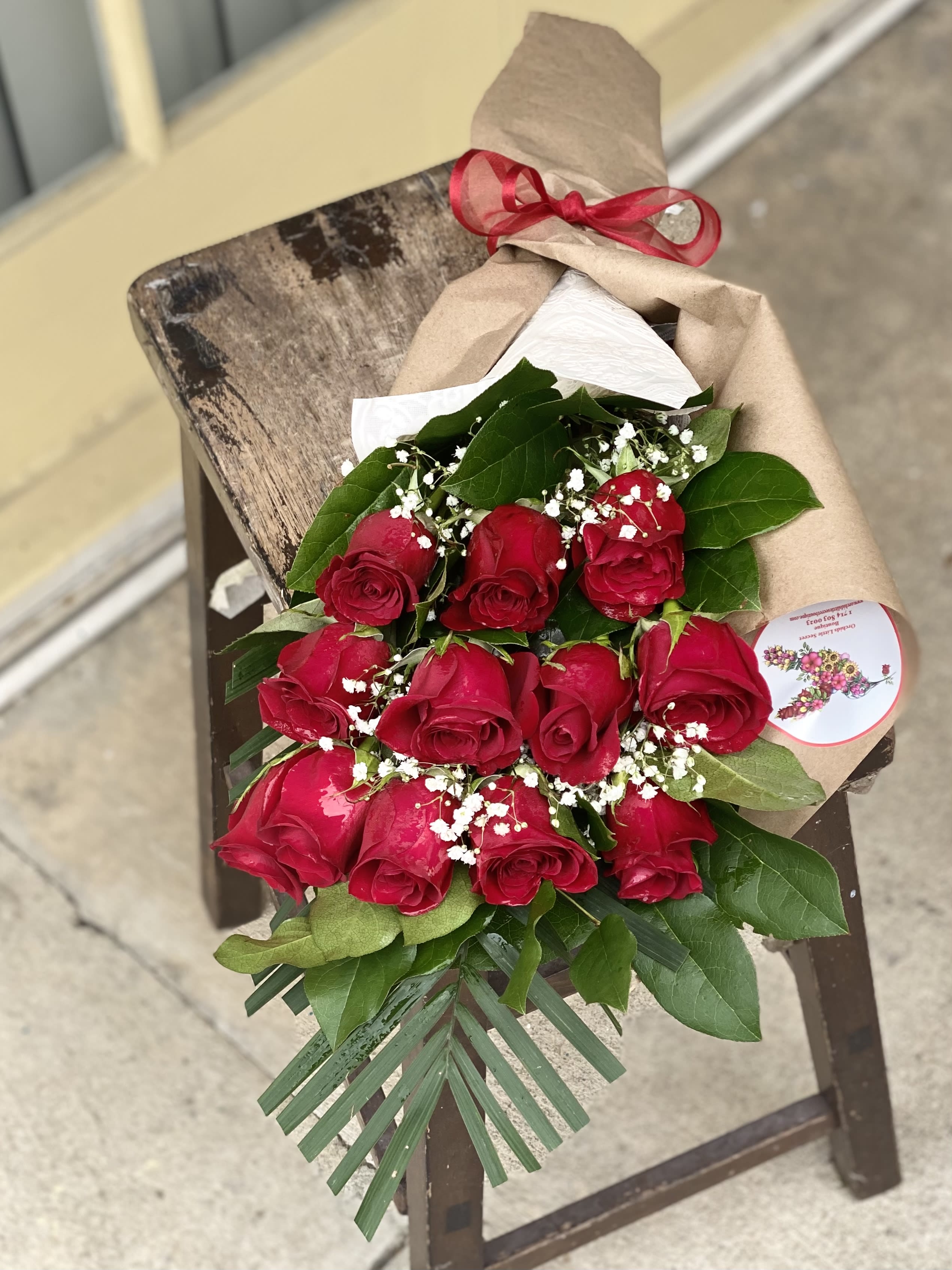 Bouquet of red roses wrapped in brown paper with a red ribbon