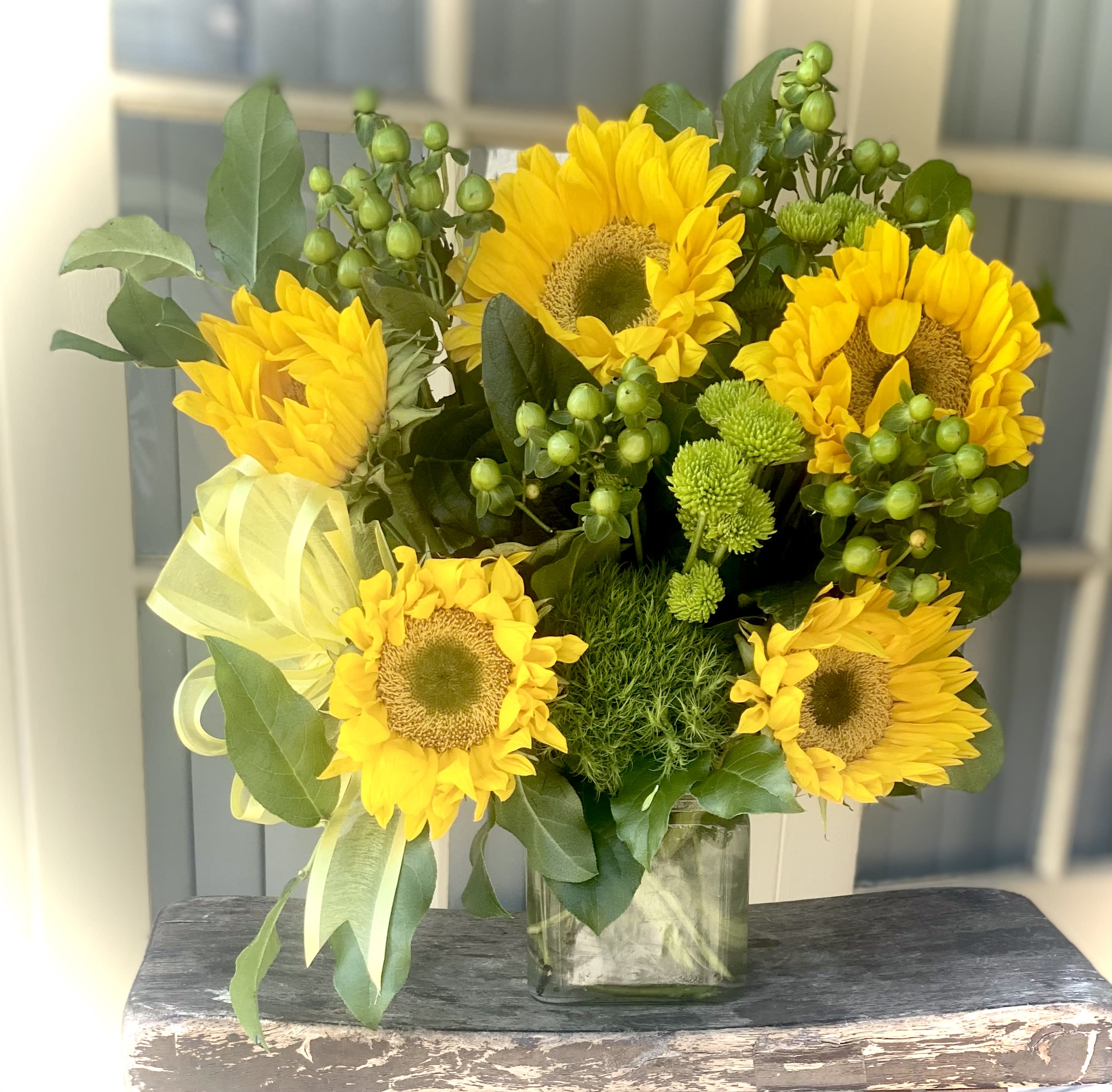Bouquet of yellow sunflowers in a clear glass vase