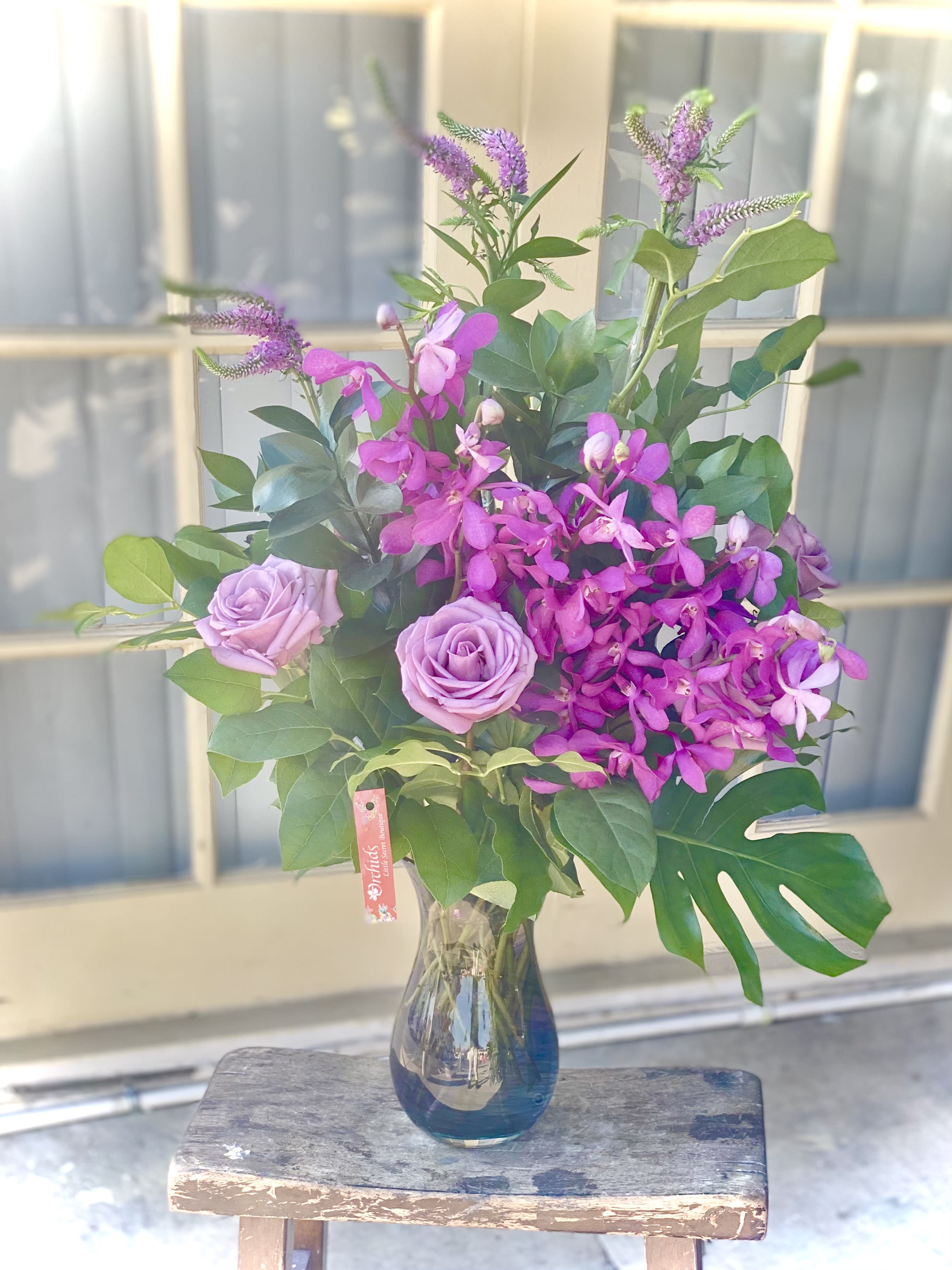 Pink roses and purple orchids in a glass vase