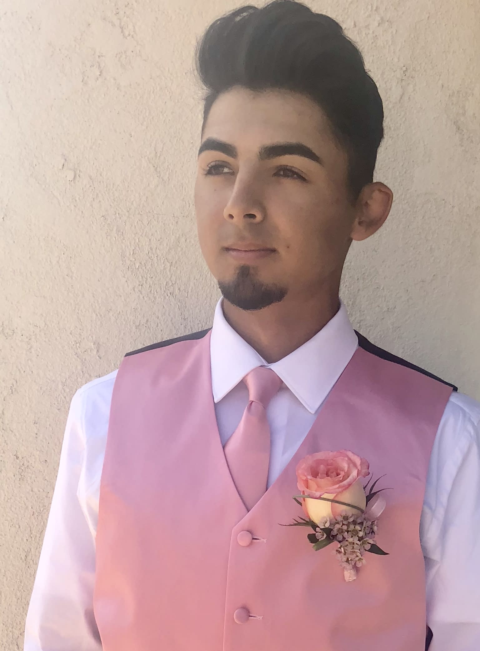 Man wearing a pink vest with a pink boutonniere