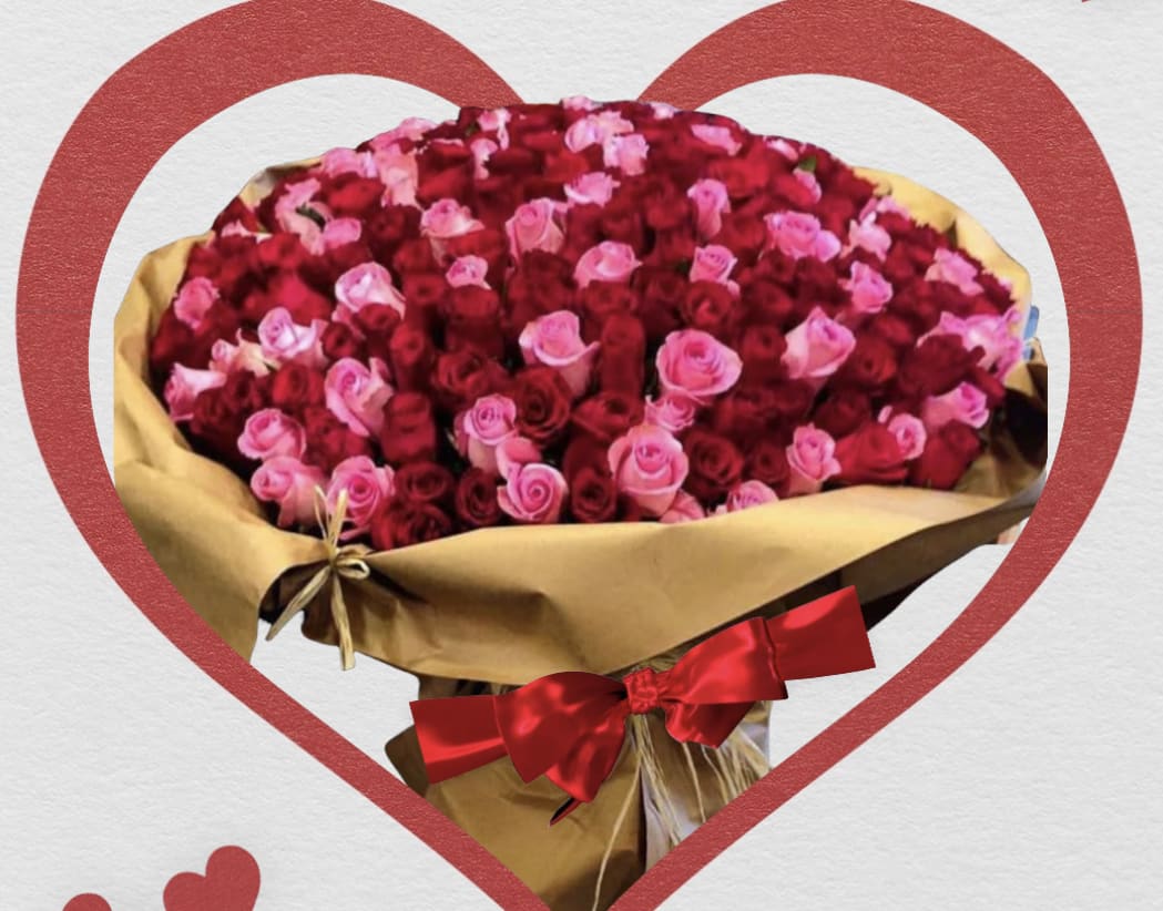 Large bouquet of red and pink roses wrapped in brown paper with a red bow