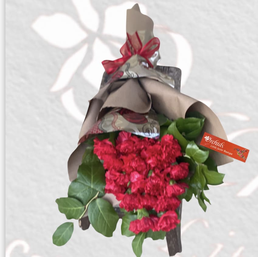 Bouquet of red carnations wrapped in paper with a ribbon