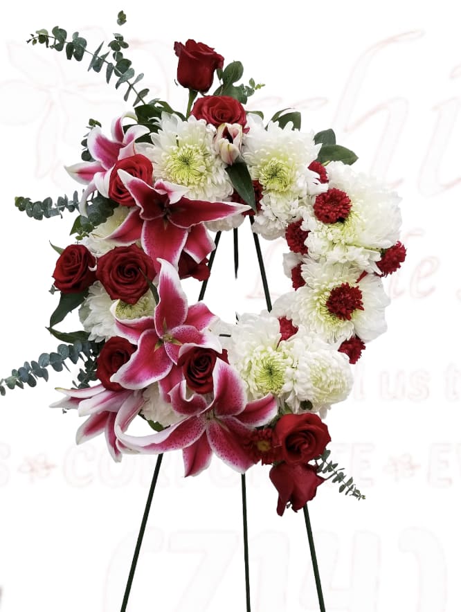 Heart-shaped floral wreath with red roses, pink lilies, and white chrysanthemums