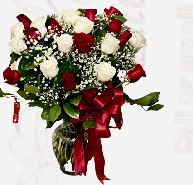 Bouquet of red and white roses in a glass vase with a red ribbon