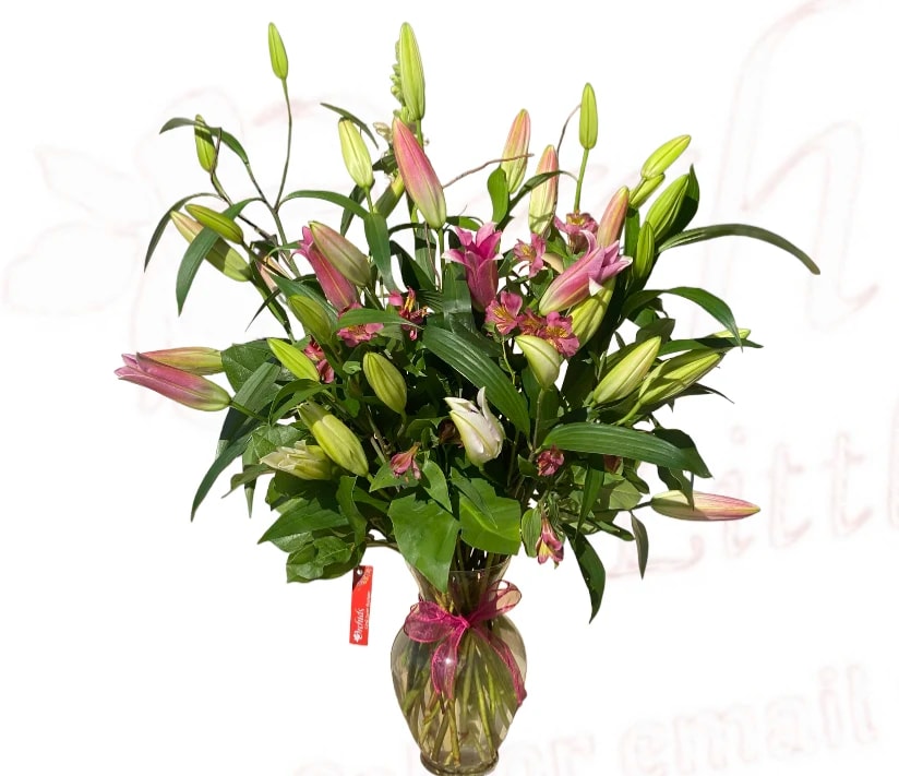 Bouquet of pink lilies in a glass vase with a ribbon