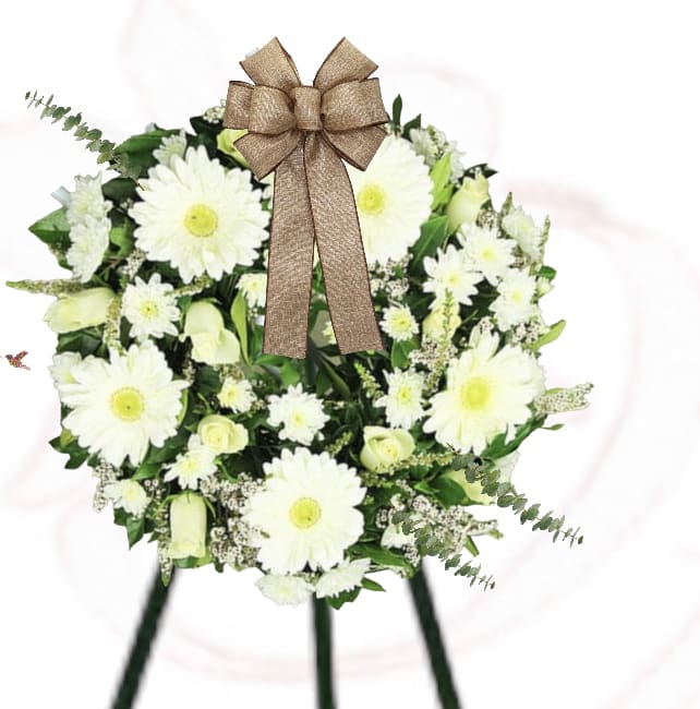 White daisy wreath with a brown bow on a stand
