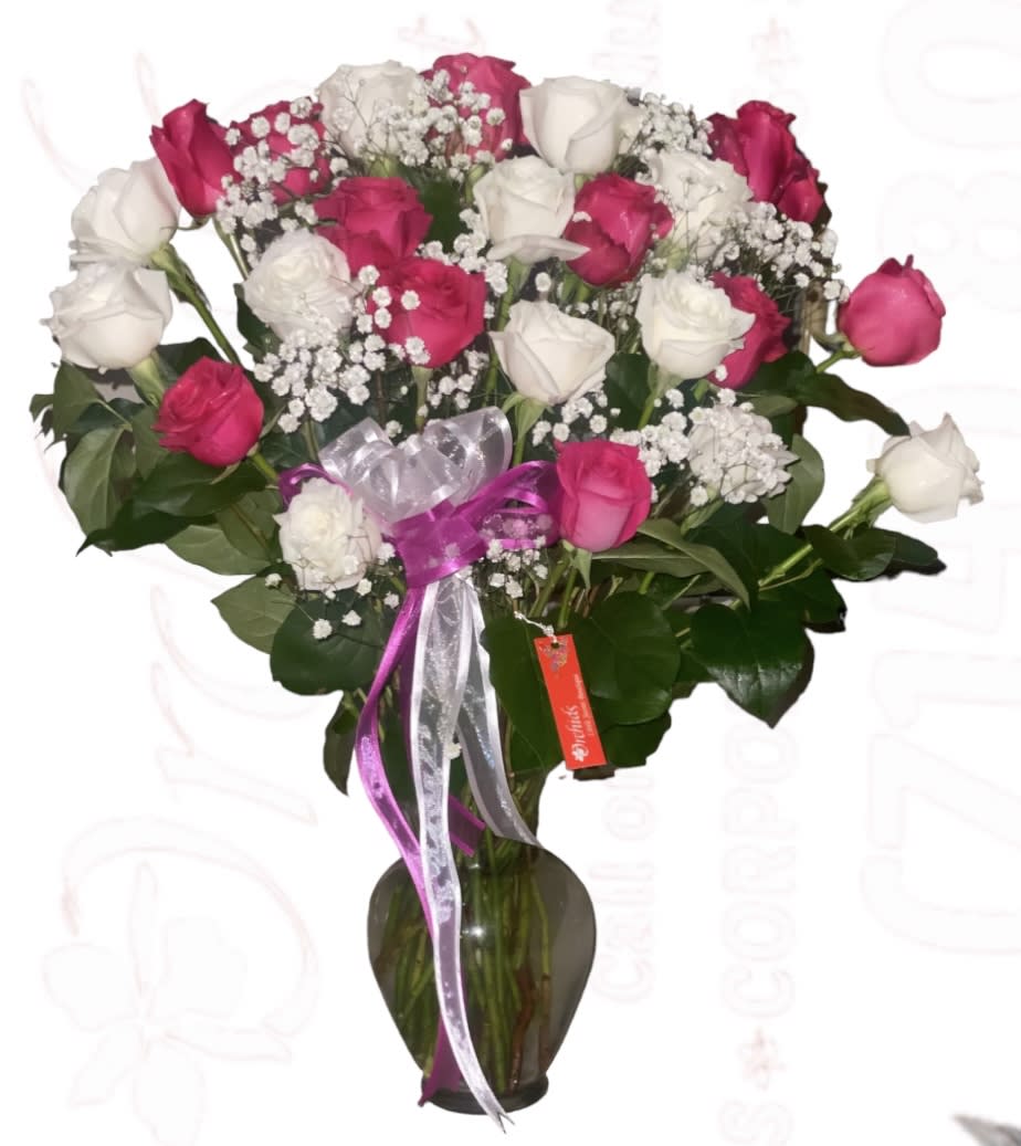 Bouquet of pink and white roses in a glass vase with ribbon