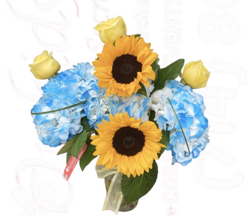 Bouquet of blue hydrangeas with yellow roses and sunflowers in a vase
