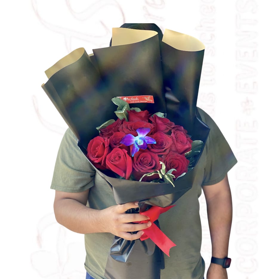 Bouquet of red roses wrapped in black paper with a red ribbon