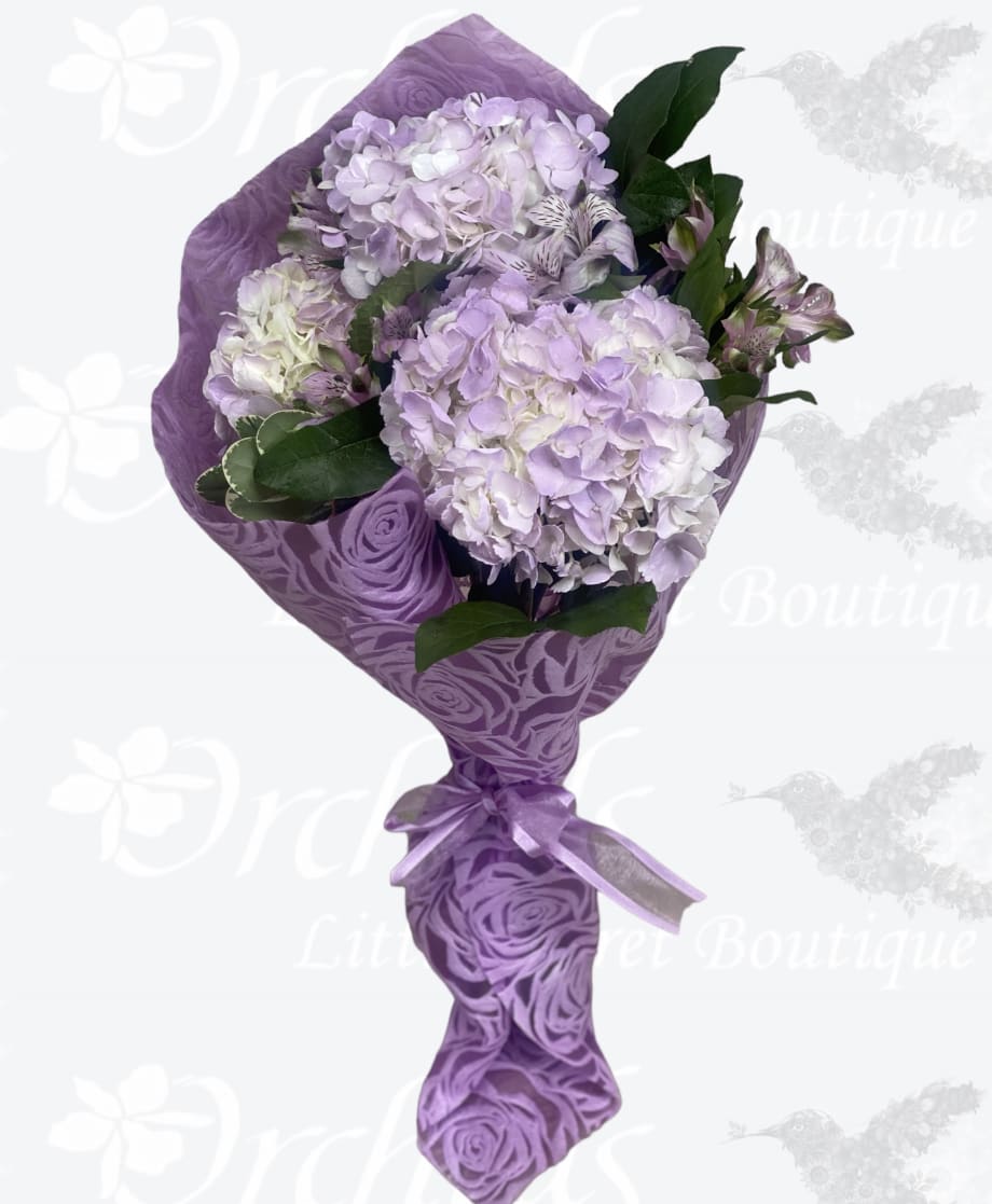 Lavender hydrangea bouquet wrapped in purple paper with a ribbon