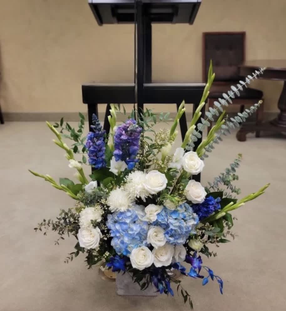 Blue and white floral arrangement with tall stems in a vase
