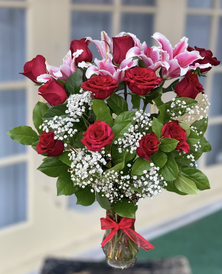 Bouquet of red roses and pink lilies in a glass vase