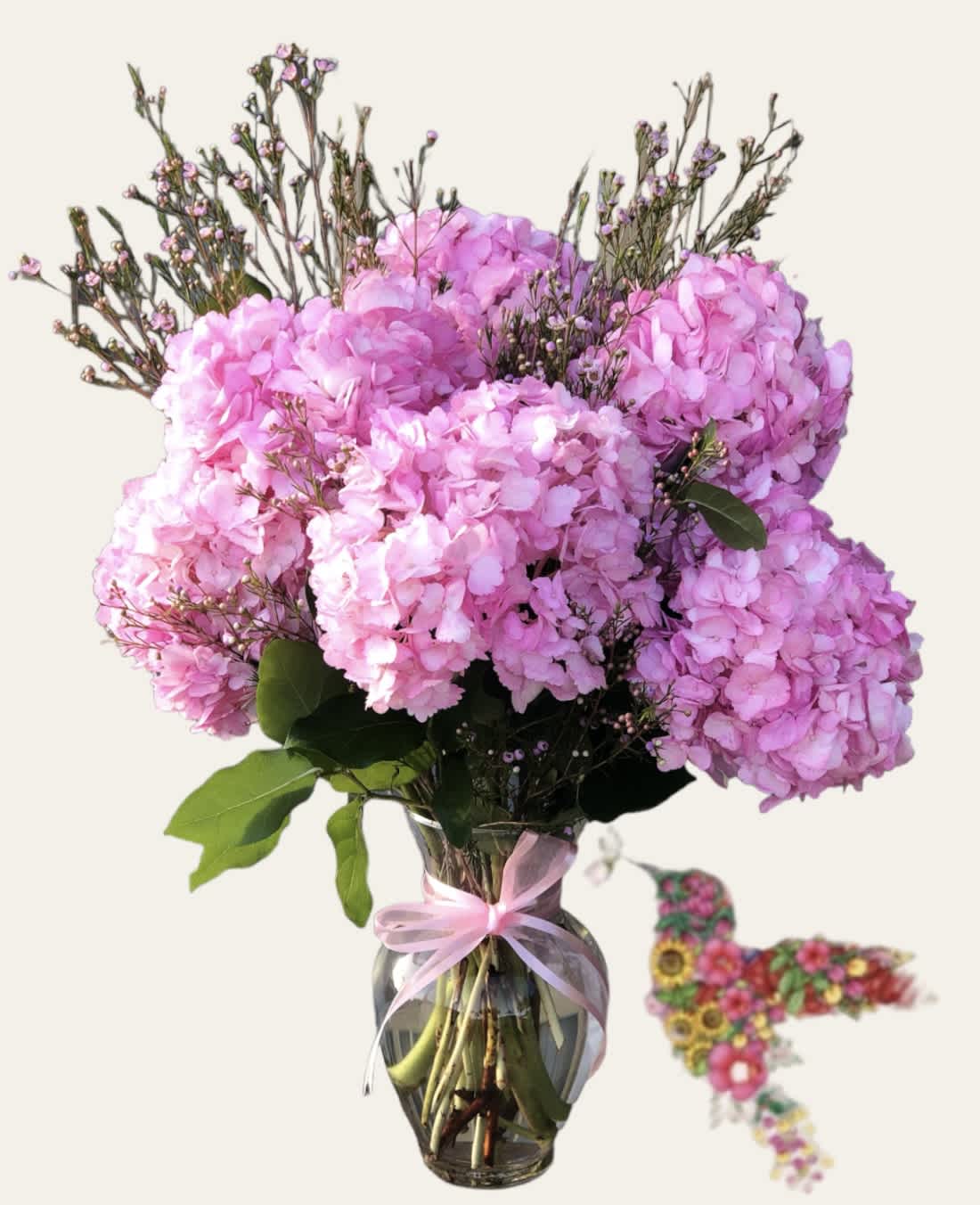 Pink hydrangea bouquet in a glass vase with a ribbon