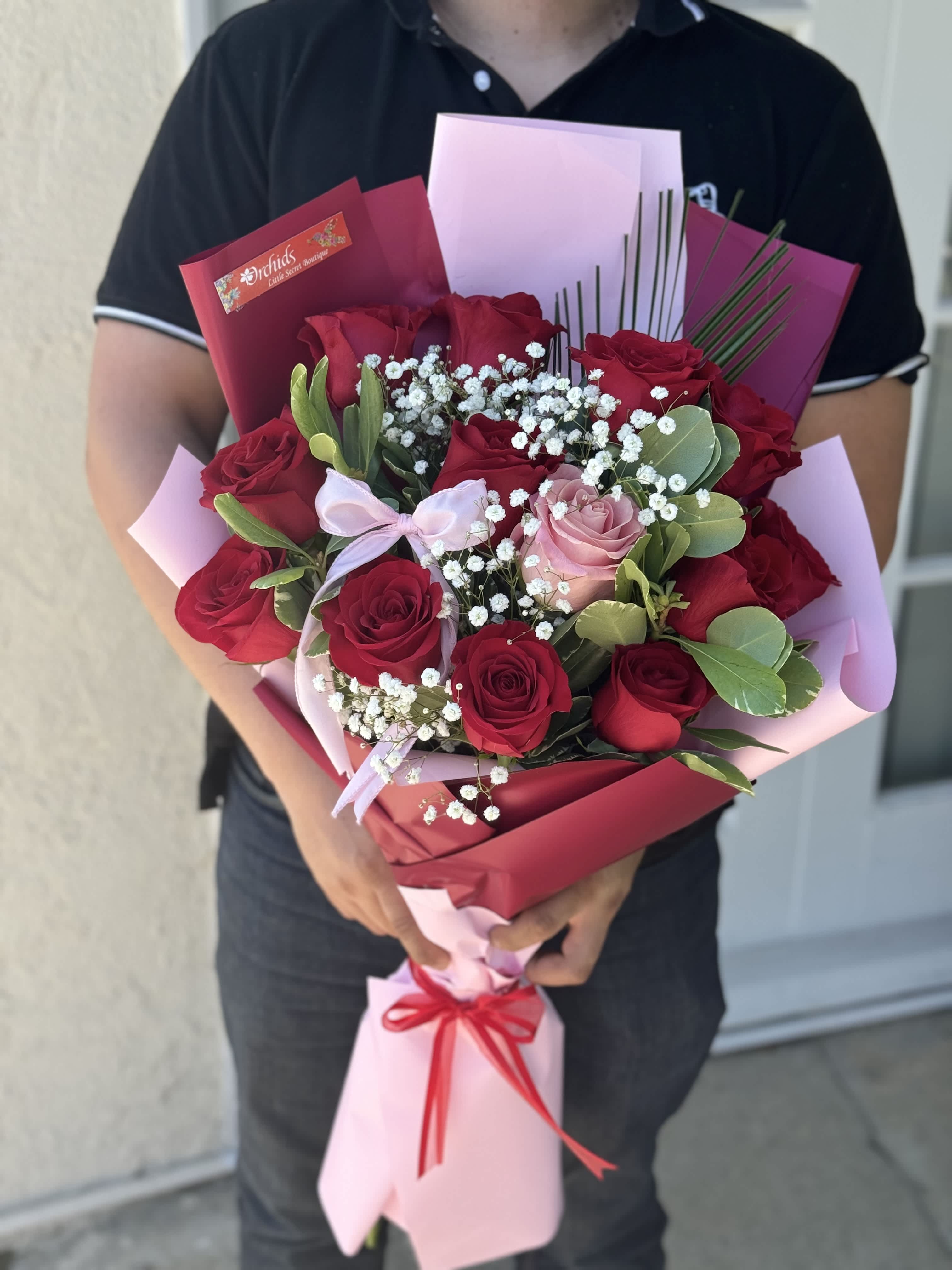 Bouquet of red and pink roses with baby's breath in pink wrapping