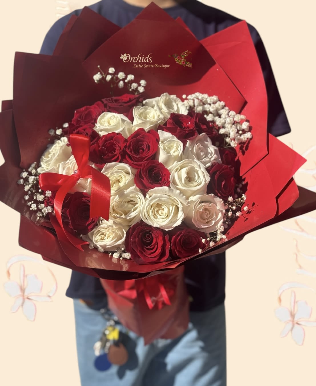 Bouquet of red and white roses wrapped in red paper with a ribbon