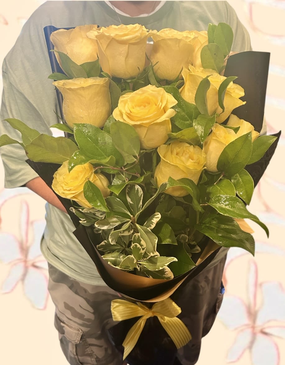 Bouquet of yellow roses wrapped in black paper with a yellow ribbon
