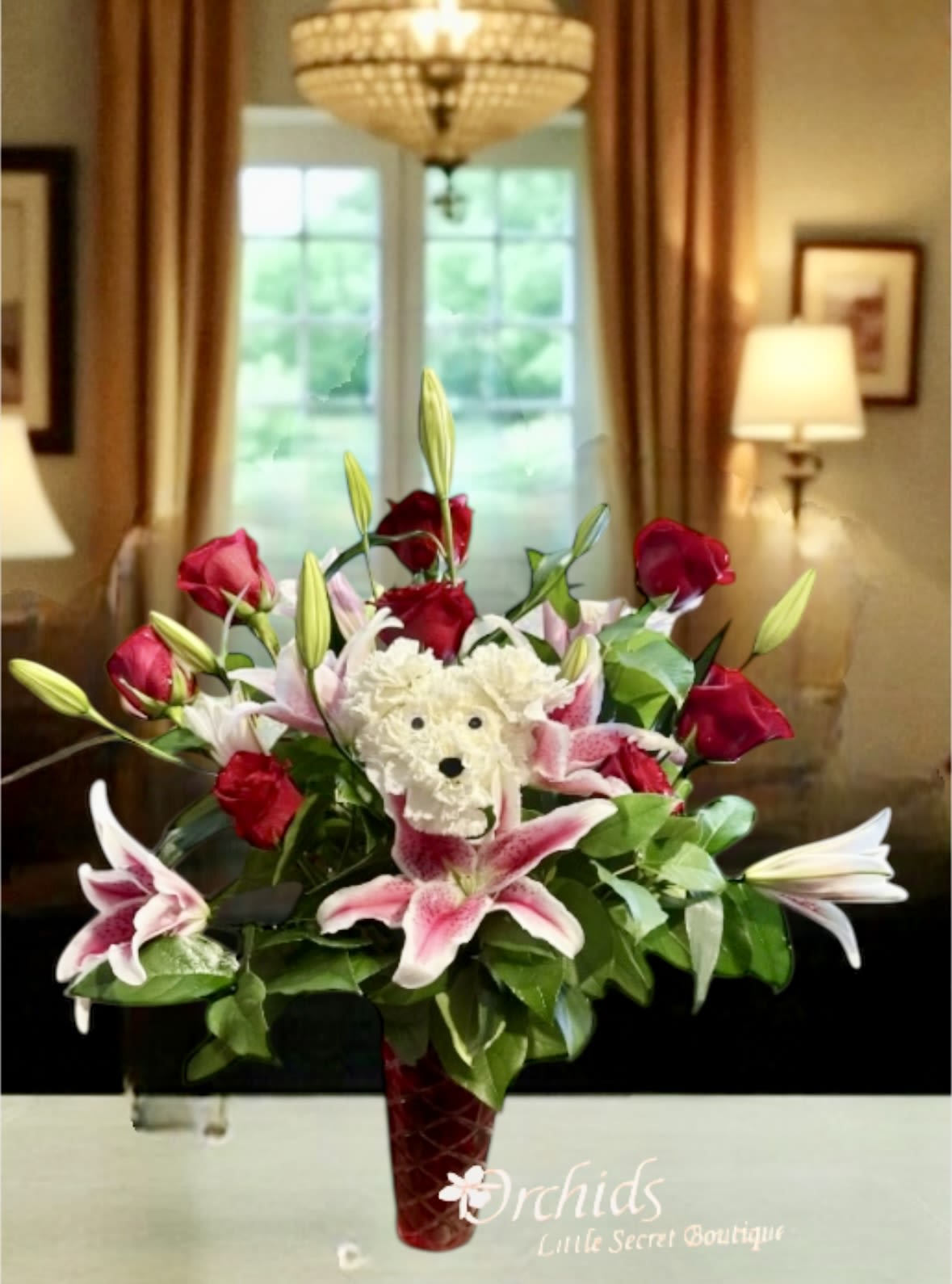 Bouquet of red roses and pink lilies in a red vase with a teddy bear center