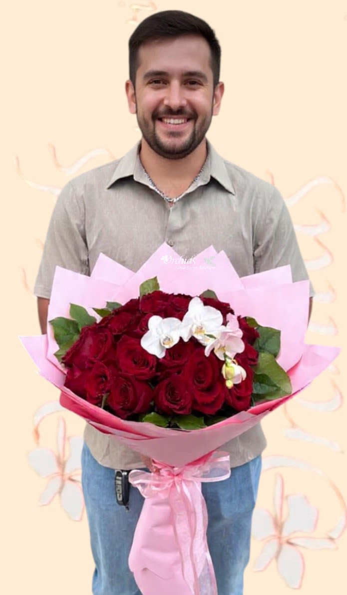 Man holding a bouquet of red roses with white orchids