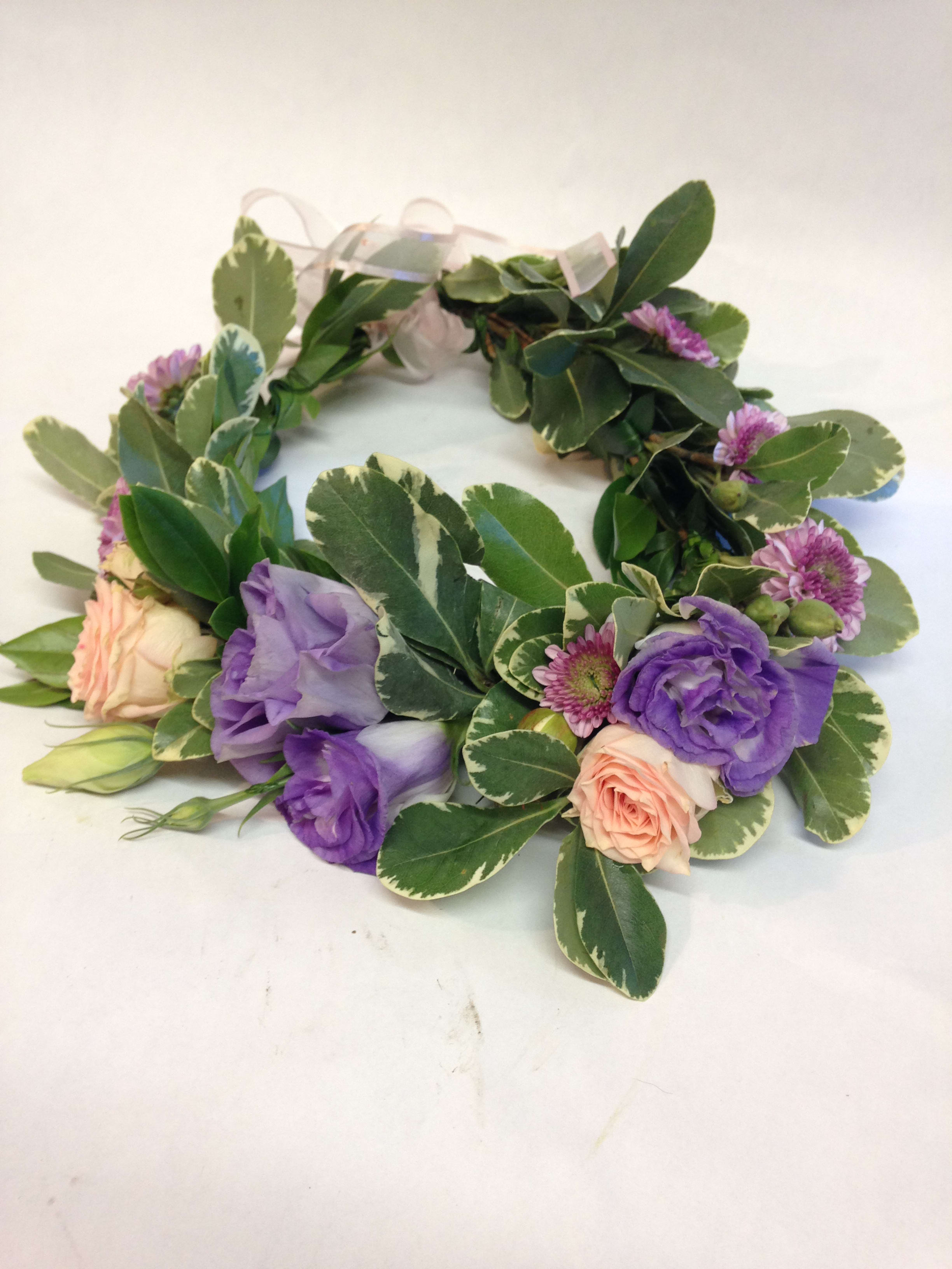 Floral wreath with purple and peach blooms on variegated greenery