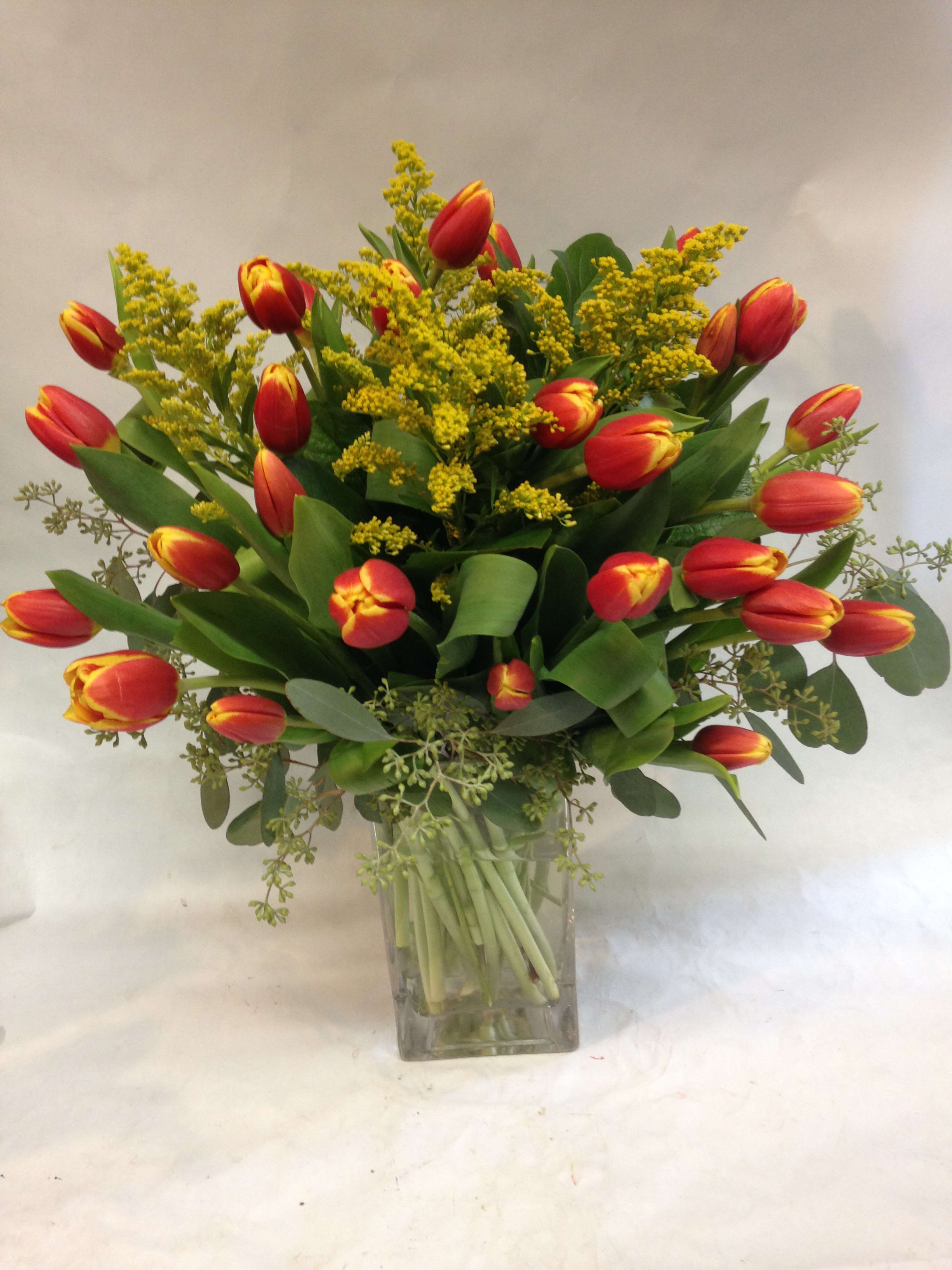Grand Sunset Tulips - These striking ombre tulips are complimented by solidago and seeded eucalyptus in a gorgeous vase.  Featured Arrangement:125.75  (30 stems tulips)