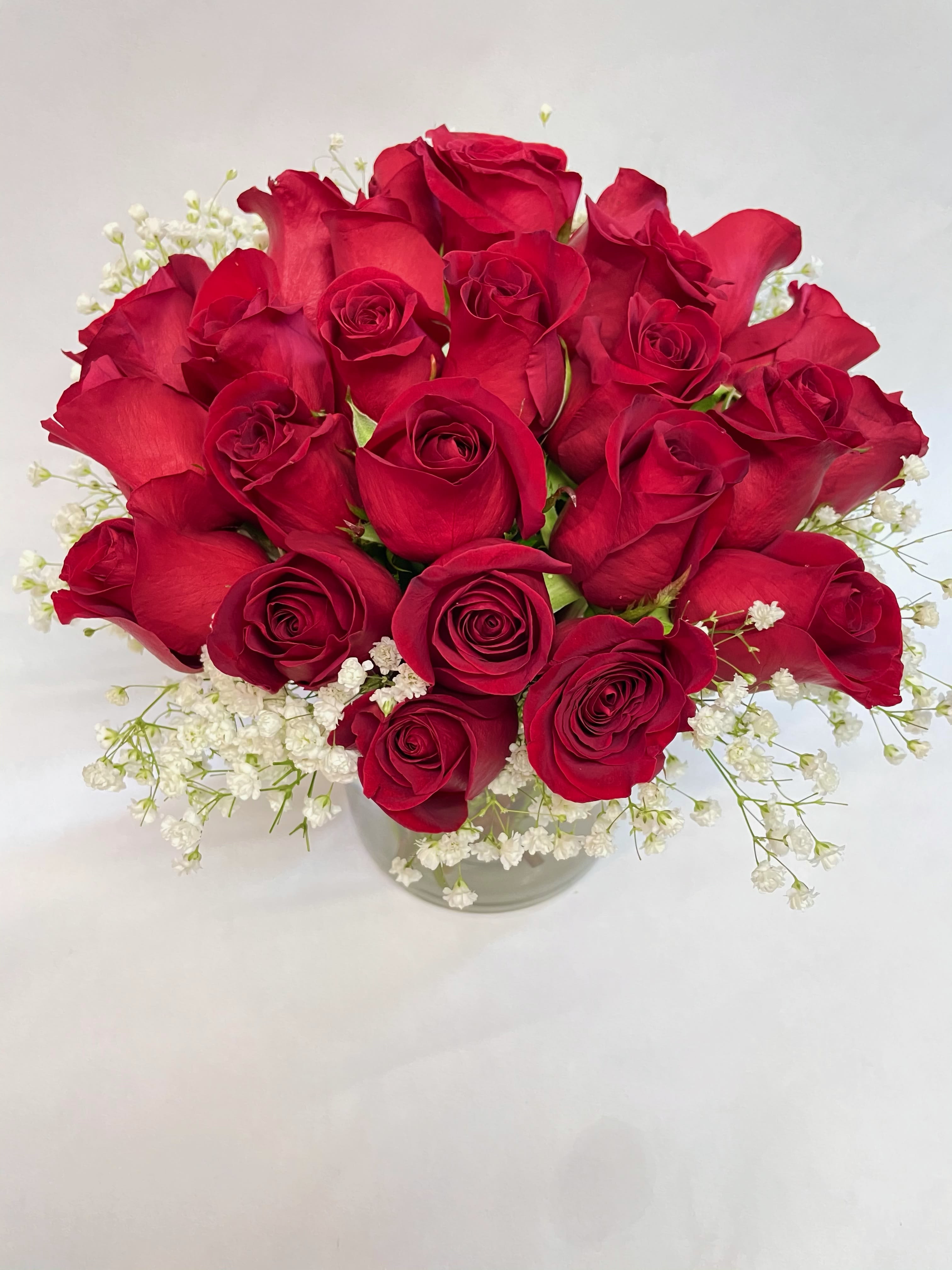 Bouquet of red roses with white baby's breath in a clear vase