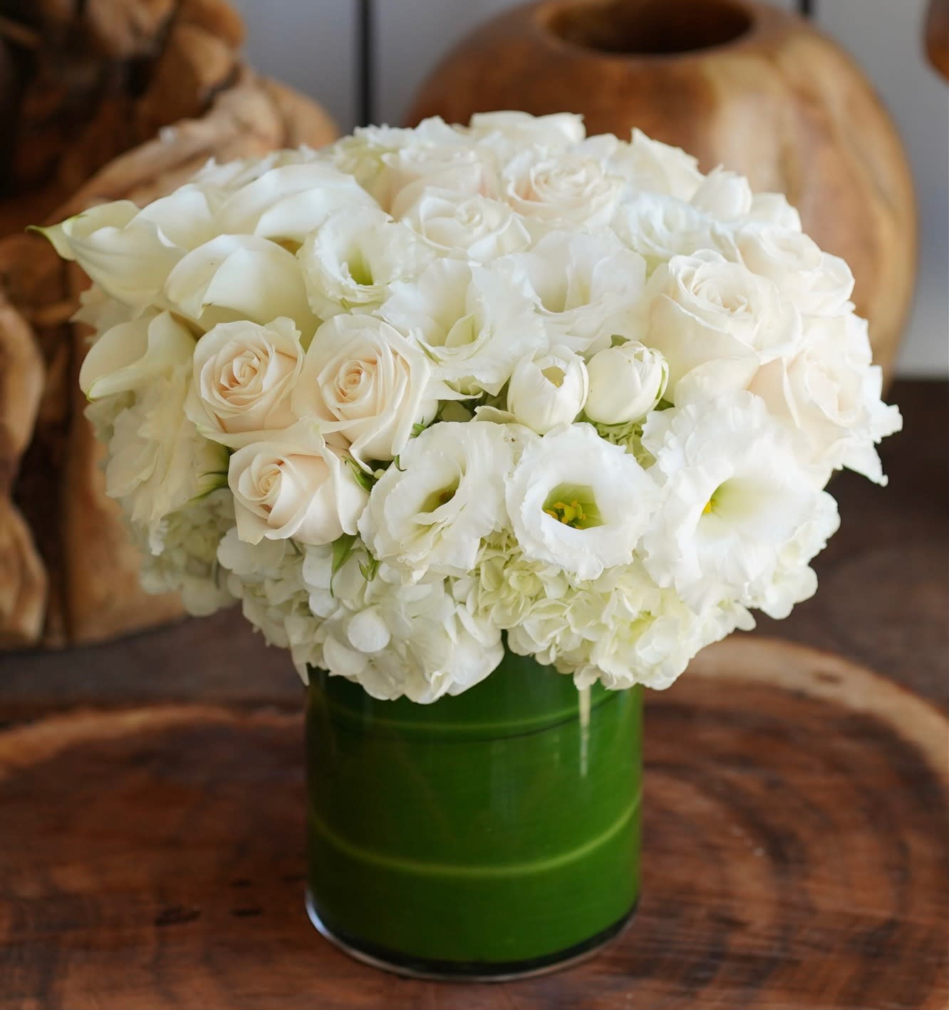 White roses and lisianthus in a green vase