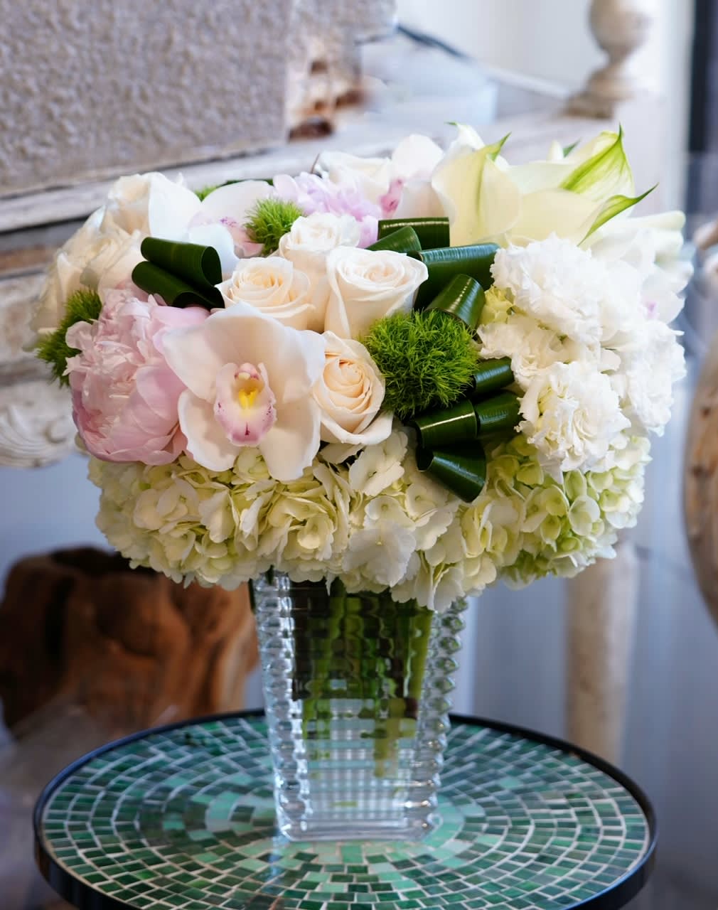 White and blush floral arrangement in a clear glass vase