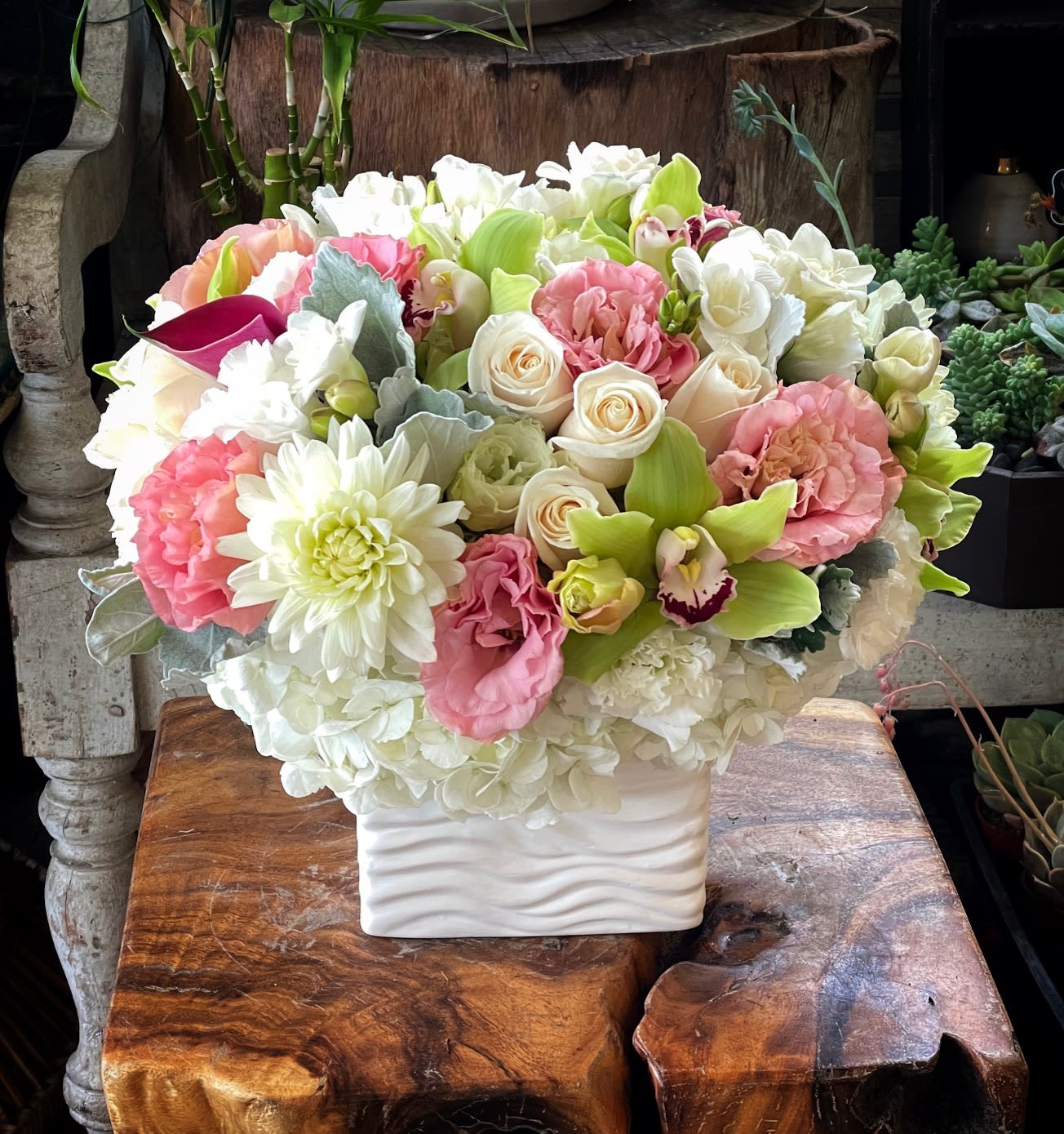 Bouquet of pink, white, and green flowers in a white vase