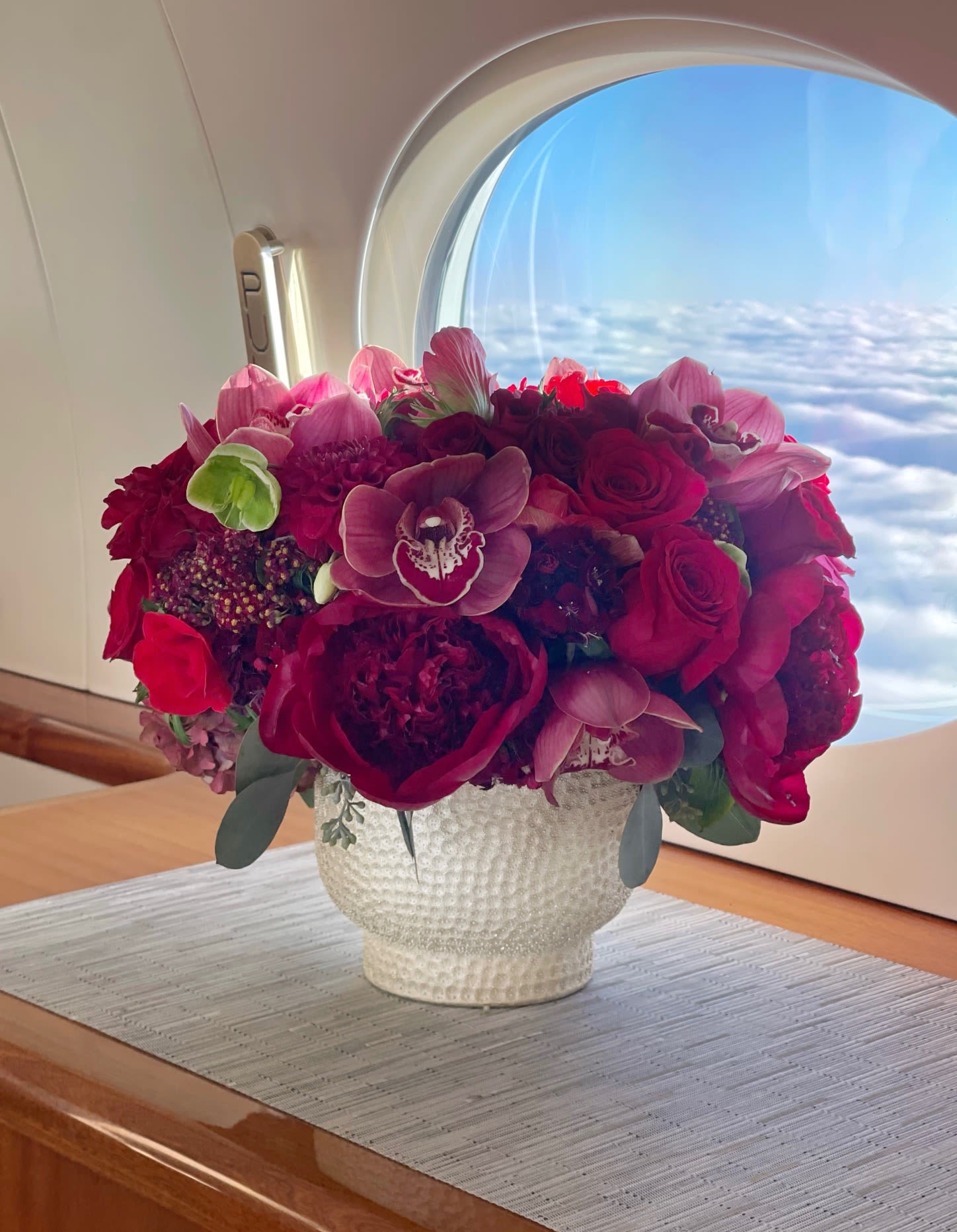 Bouquet of red and pink flowers in a white textured vase