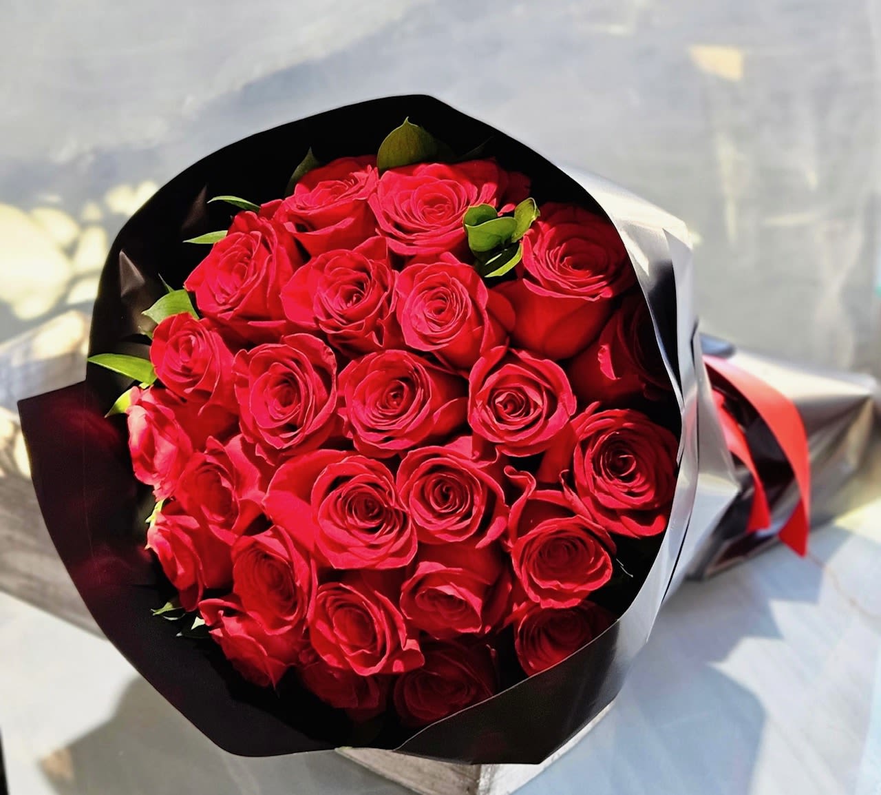 Bouquet of red roses wrapped in black and white paper