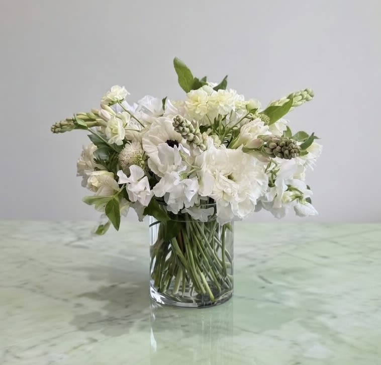 Beautiful White - Lisianthus, Dahlias, Sweet Pea, and more white flower with greenery in glass vase. 