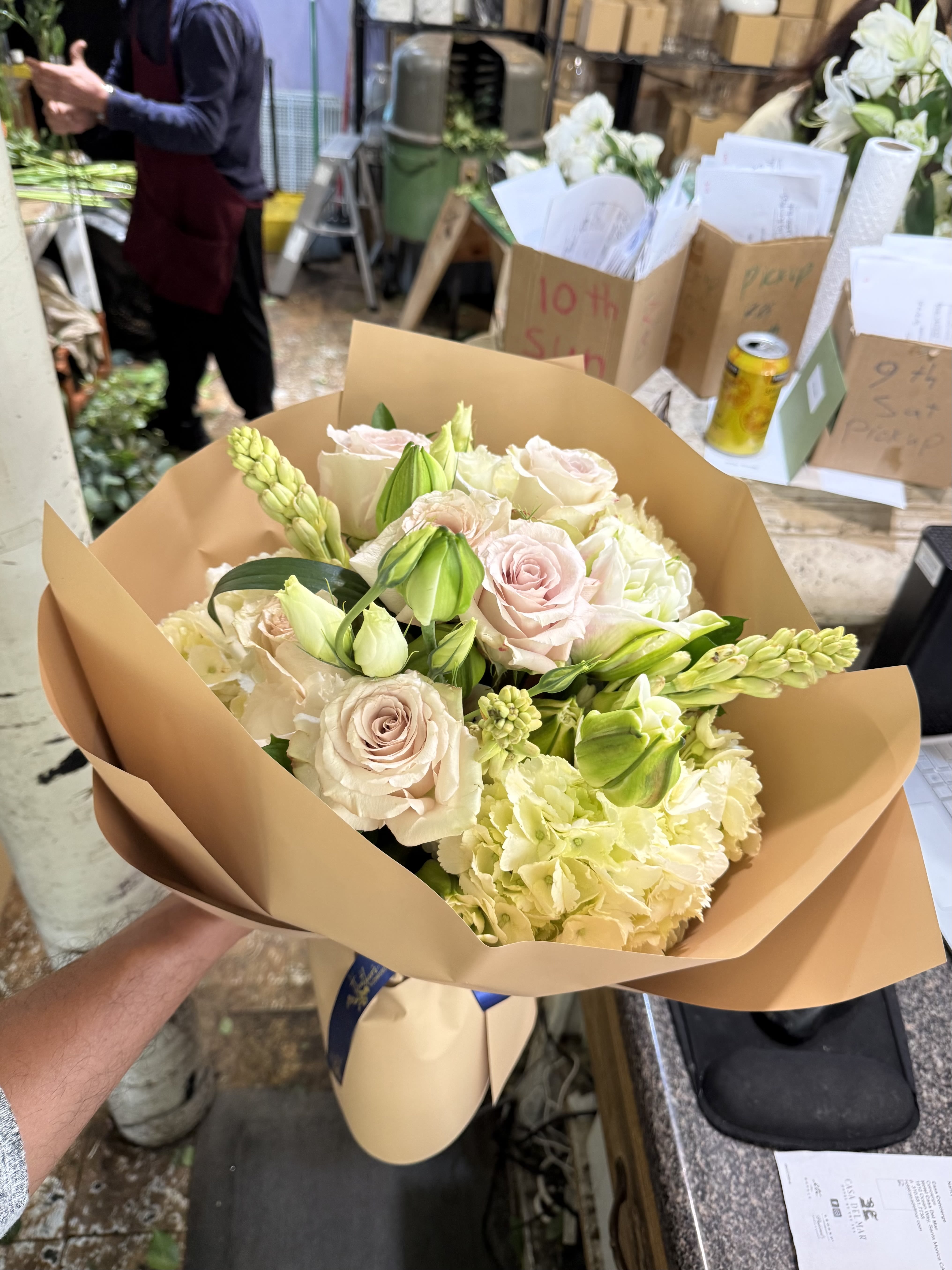 Champagne Garden - A refined gathering of blush roses, creamy hydrangea, elegant lily buds, and fragrant stock, wrapped in warm neutral paper for a timeless, effortless look. Hand-wrapped in signature kraft paper, it's a bouquet that feels both luxurious and understated-perfect for celebrating life's most meaningful moments. 