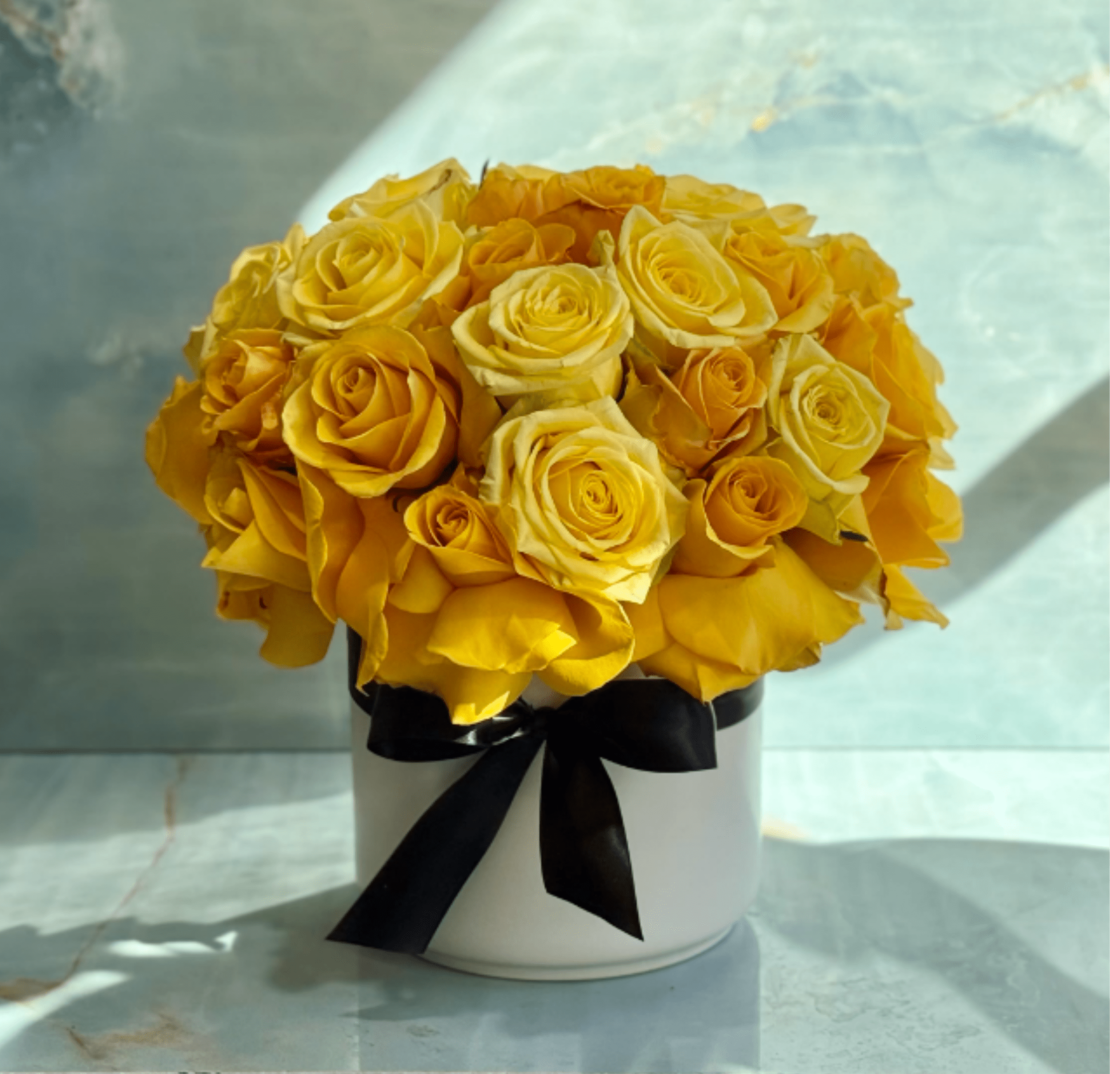 Yellow rose bouquet in a white hatbox with a black ribbon