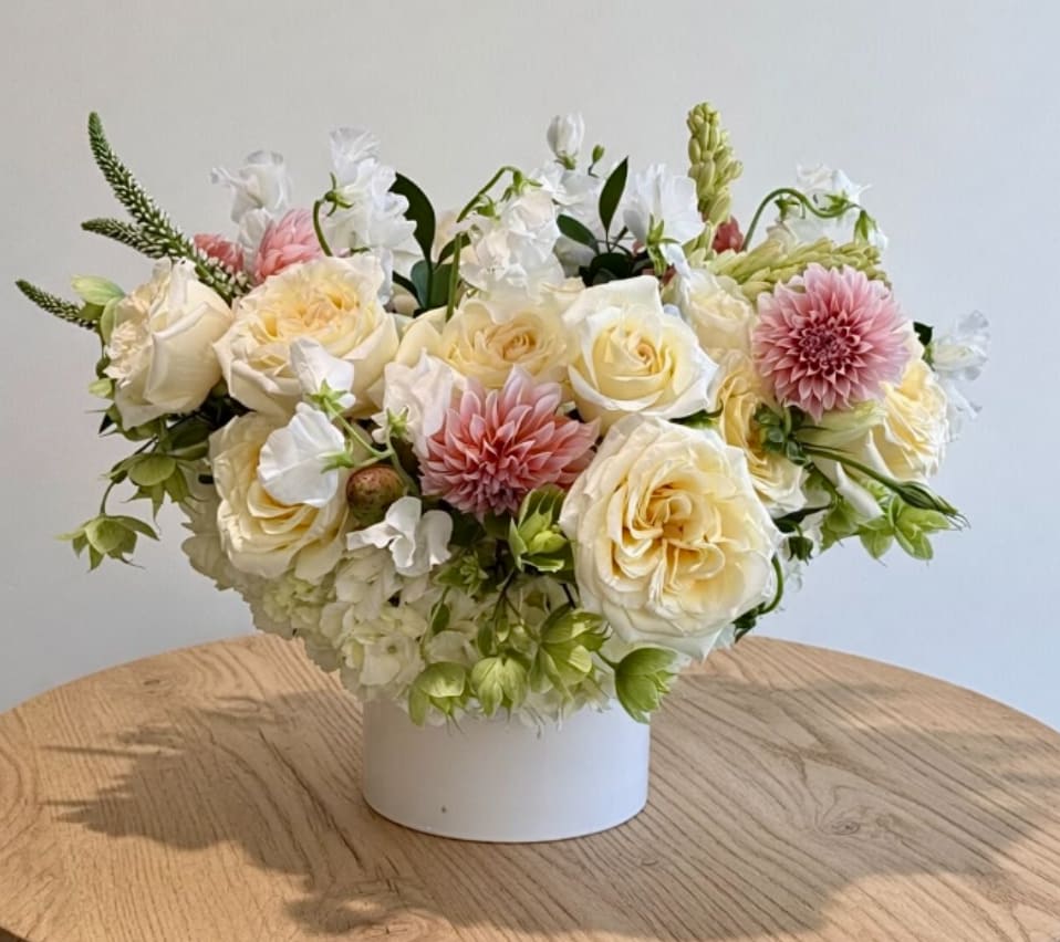 Cream and pink floral arrangement in a white vase
