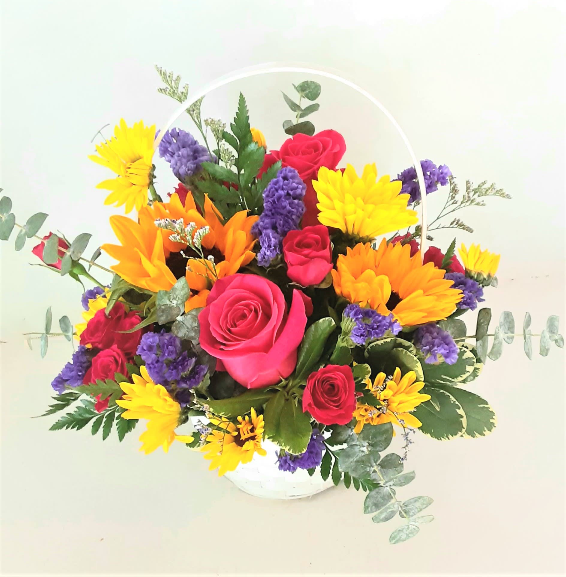 Basket arrangement of pink roses, yellow daisies, and purple flowers