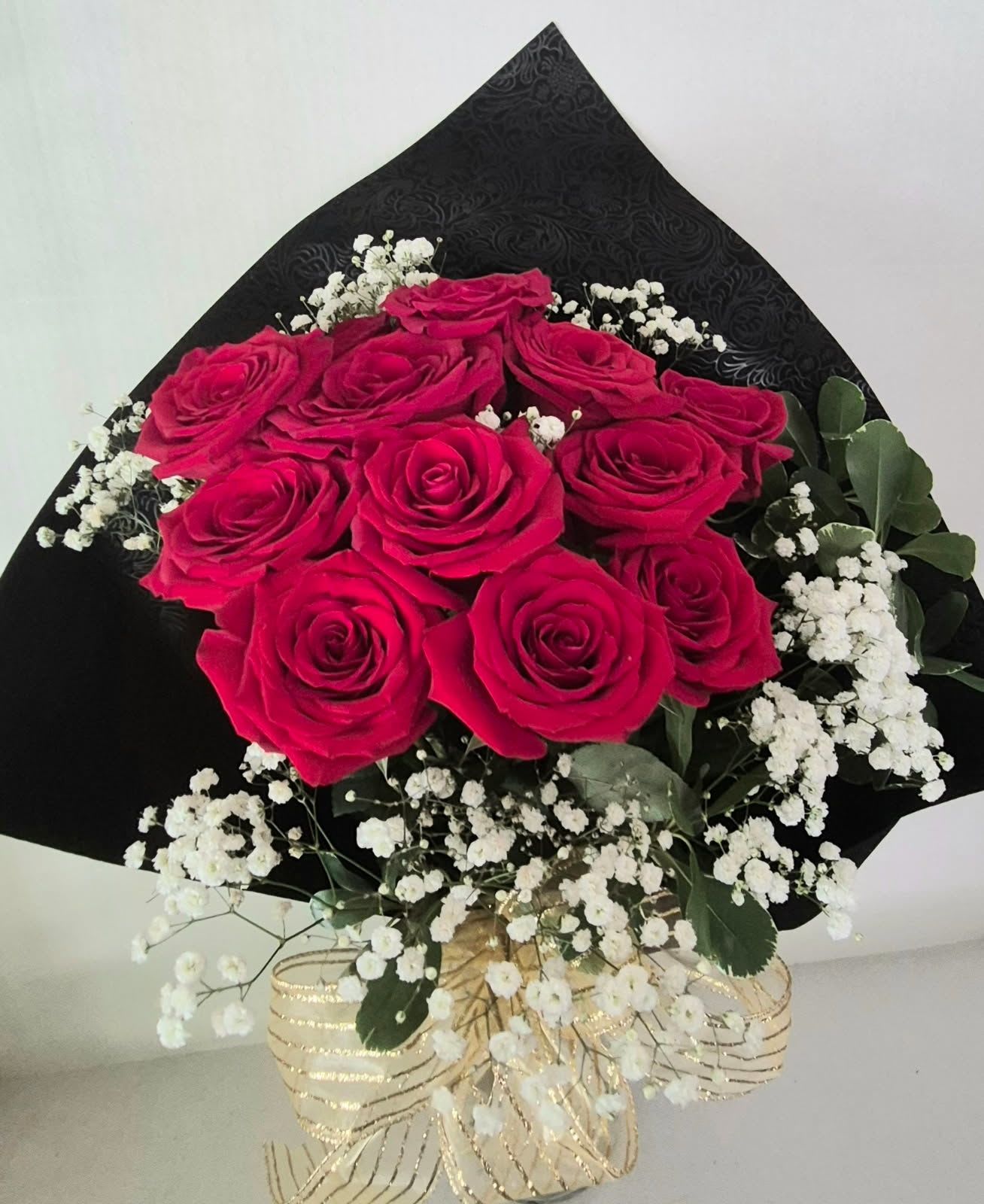 Red Roses Wrapped - 12 Roses in a designer embossed wrap with greenery and baby's breath, ready for arranging by the recipient. Perfect for graduations and event presentations.
