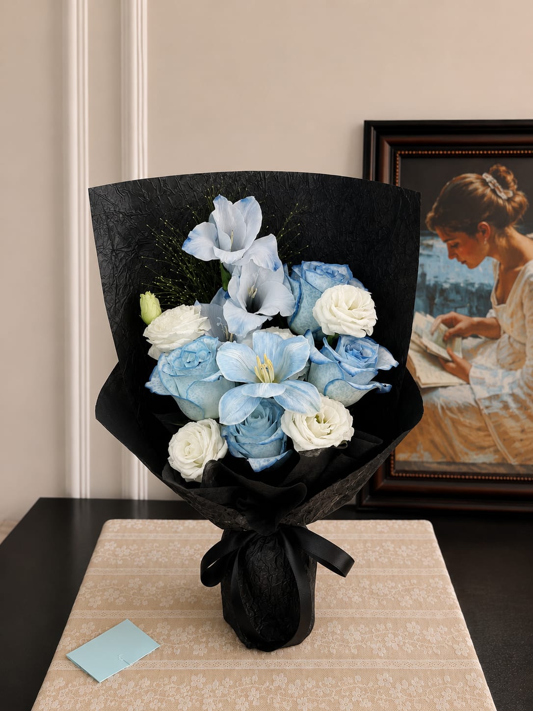 Blue and white bouquet wrapped in black paper with a ribbon