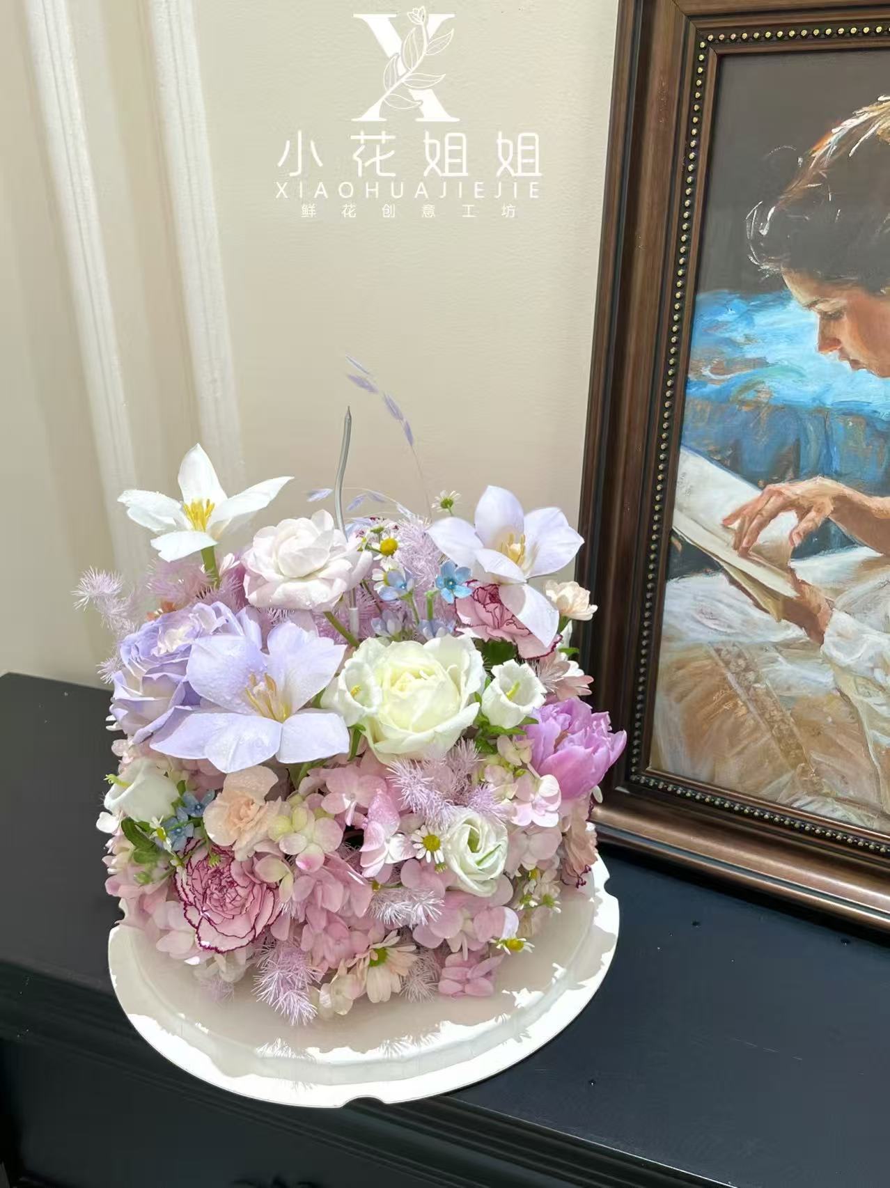 Pastel bouquet with white and lavender flowers in a white tray