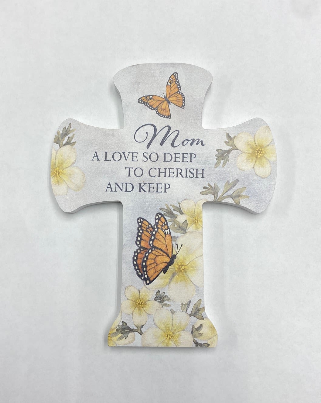 Cross-shaped memorial plaque with butterflies and flowers reading "Mom"