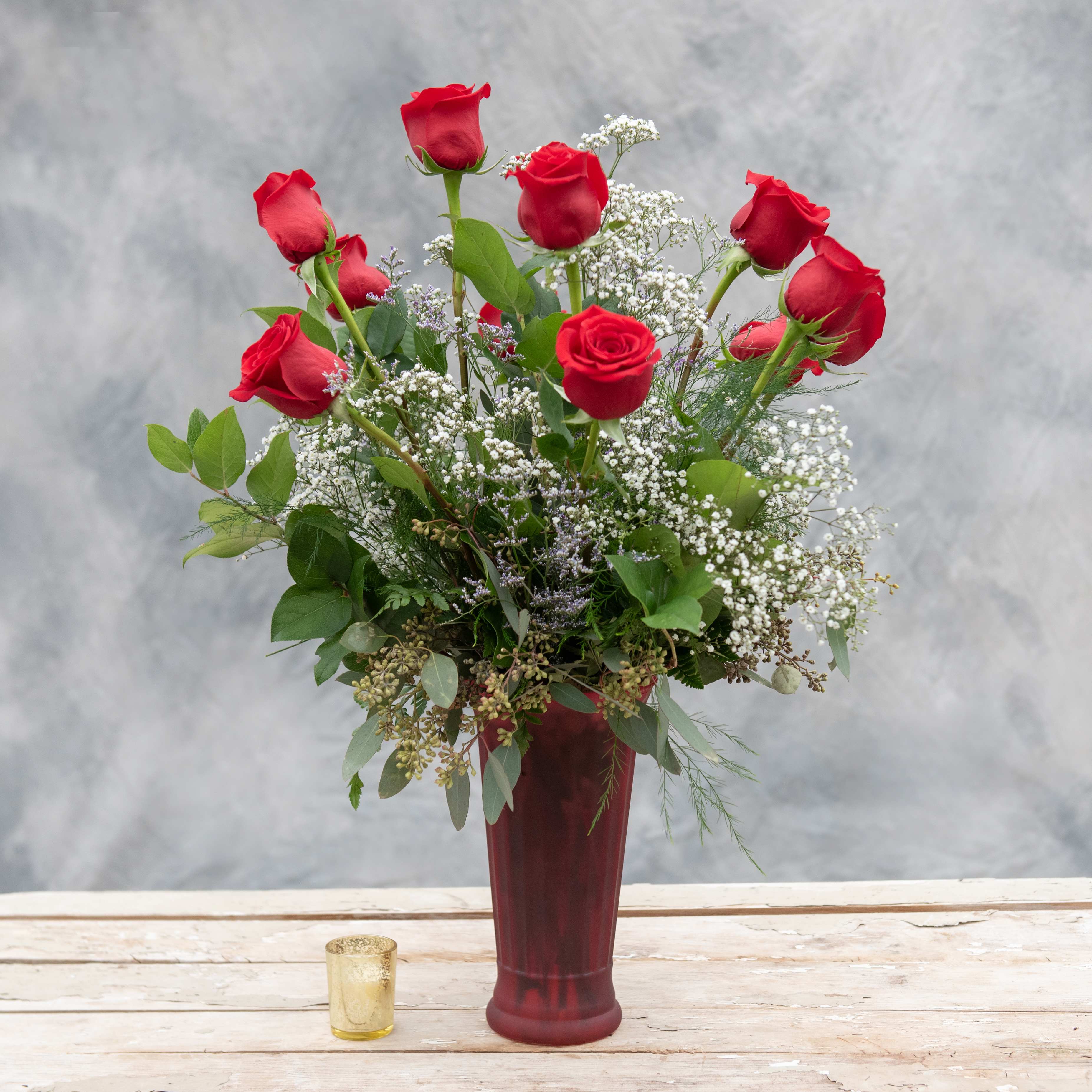 Deluxe Rose Arrangement - One dozen long stemmed red roses arranged in our ruby rose vase, accented with premium greens and unique accent flowers and branches. Regular price is for one dozen, choose deluxe pricing for two dozen or premium pricing for three dozen. Other rose colors are available, call for custom options