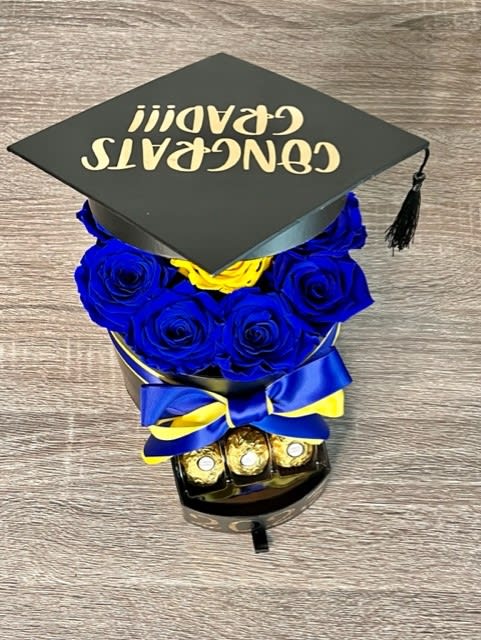 Blue roses arranged under a graduation cap with chocolates and ribbon