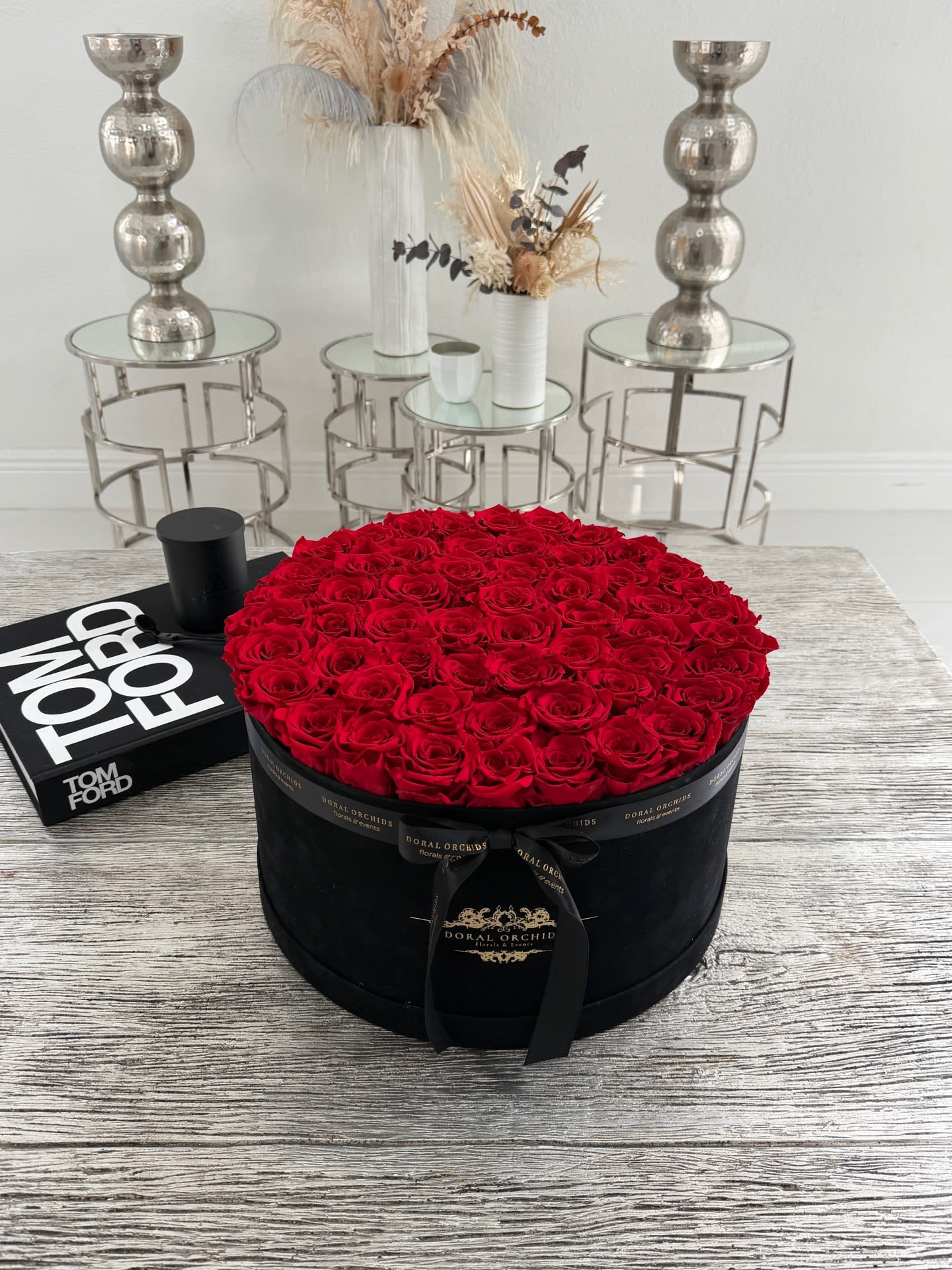 Luxury Red Preserved Roses Velvet Box™ - A striking expression of luxury and romance, this grand round arrangement features 55 premium preserved red roses meticulously placed in a sleek black velvet hat box. Designed with a perfectly flat, full surface for a modern and elegant look, each rose is carefully selected for its rich color and long-lasting beauty. These preserved roses maintain their softness and appearance for years, making this piece a timeless statement. Finished with a signature ribbon, it’s perfect for anniversaries, celebrations, or an unforgettable luxury gift.